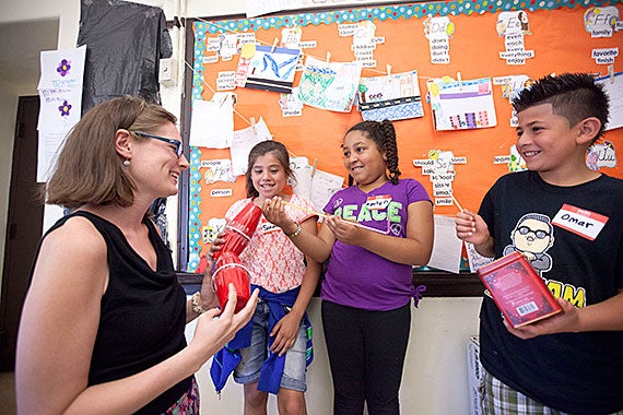 McKay School teacher Amy Blenk (from left) works with students Sarah Martinez, Emily Depina, and Omar Posada, who made musical instruments out of rock-filled cups to interpret a passage in “The Little Prince” with sound.