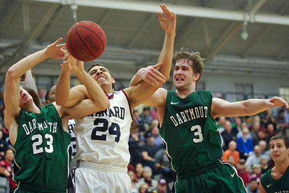 Harvard forward Jonah Travis '16 (center) fights two Dartmouth defenders for a loose ball.