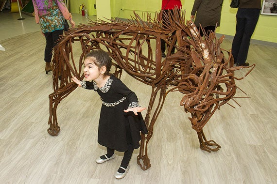 Unbound Visual Arts unveils a new exhibit at the Ed Portal gallery. Valentina Davos, 4, makes a face while her mother photographs her next to Wendy Klemperer's "Fierce Wolf."  Photos by Jon Chase/Harvard Staff Photographer