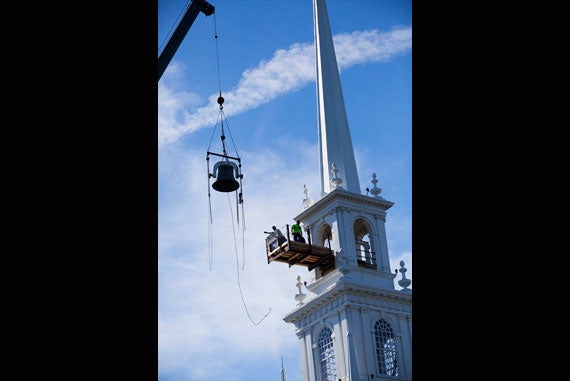 A massive crane carefully lifts the old bell from the Memorial Church tower and gently lowers it to the ground. 