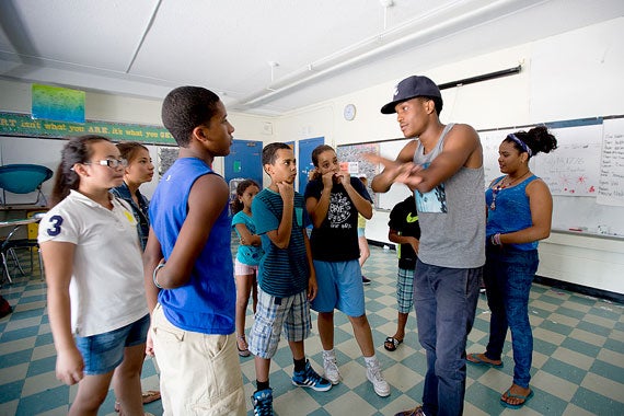 Jaydee Flemmings (wearing hat), a senior counselor in Harvard's Boston Refugee Youth Enrichment (BRYE) camp, leads dance rehearsal.  