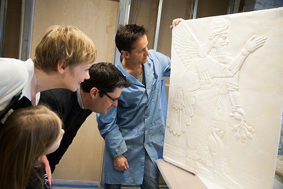 Agnete Lassen (from left), Alma Barjamovic (age 6), Gojko Barjamovic, and Adam Aja examine one of the plaster casts. 