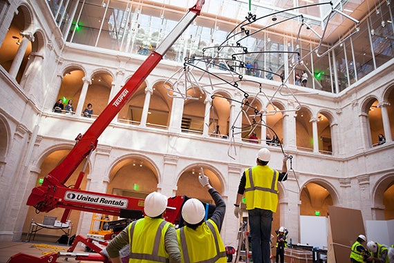 Museum staff work to hang the mobile. Carlos Amorales called the work “an expansion of the building."
