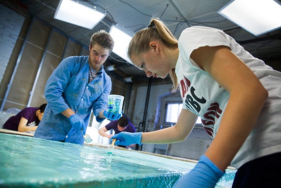 Classmates Haakon Sigurslid ’18 (left) and Georgia Stirtz ’17 mix together the bright-green silicone that will form the mold for a new resin cast. 