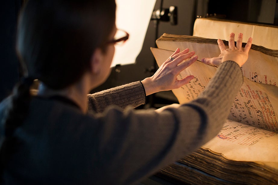 Imaging technician Theresa Kelliher photographs a 13th-century volume of musical chants.