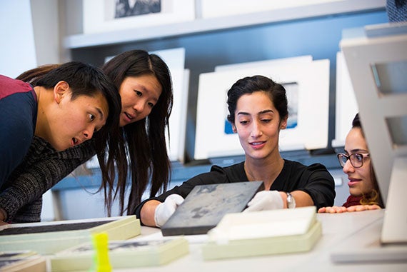 Adam Jiang '17 (from left), Eileen Feng '17, museum installer and art handler Elizabeth Sirrine, and Audria Amirian '18 study a woodblock from the collections. 