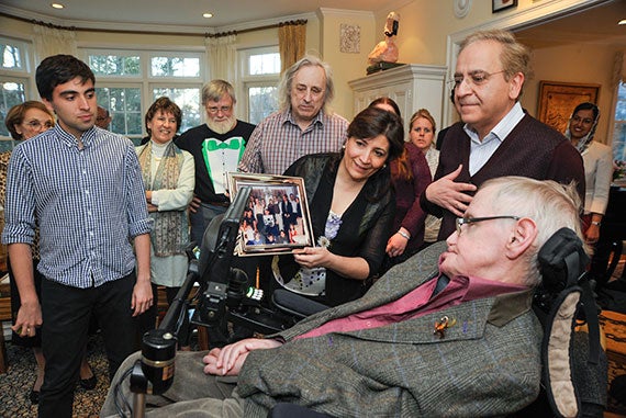 Keyon Vafa '16 (left) watches as his mother and father, Afarin and Cumrun Vafa, show Stephen Hawking a photo taken during Hawking's visit to their home years ago. 