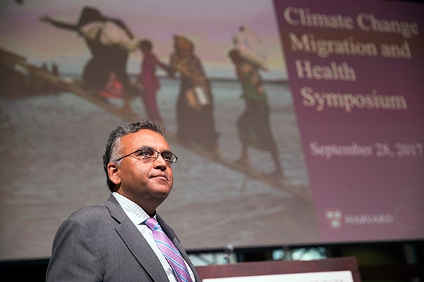 Ashish Jha gives welcoming remarks during the Harvard Global Health Institute symposium on Climate Change, Migration and Health, inside the Knafel Center (Radcliffe Gym).
