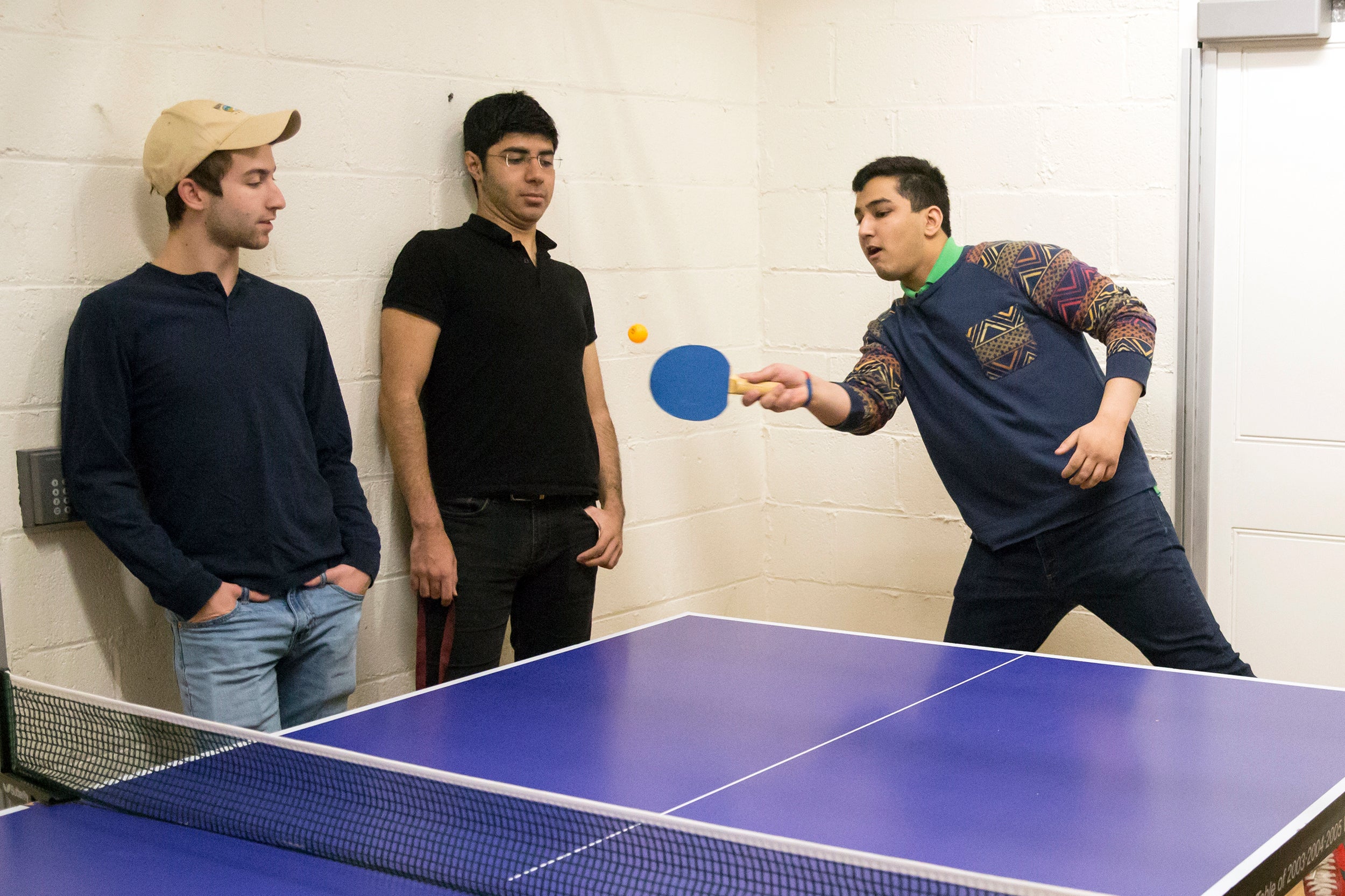 Roommates in Wigglesworth around ping pong table: (l to r) Scott Kall '20 (MA), Soheil Sadabadi '20 (Iran), and Arpan Sarkar '20 (TN), with paddle.