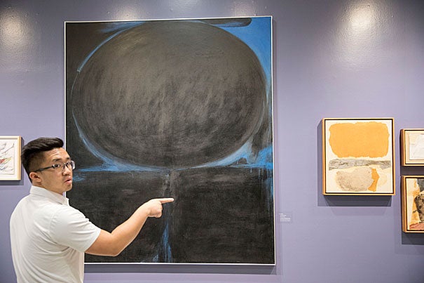 This untitled piece from 1963 contains large geometric forms of black paint edged by a vibrant blue. Justin Wong, program assistant for the Fairbank Center for Chinese Studies, views the work at the CGIS exhibit.