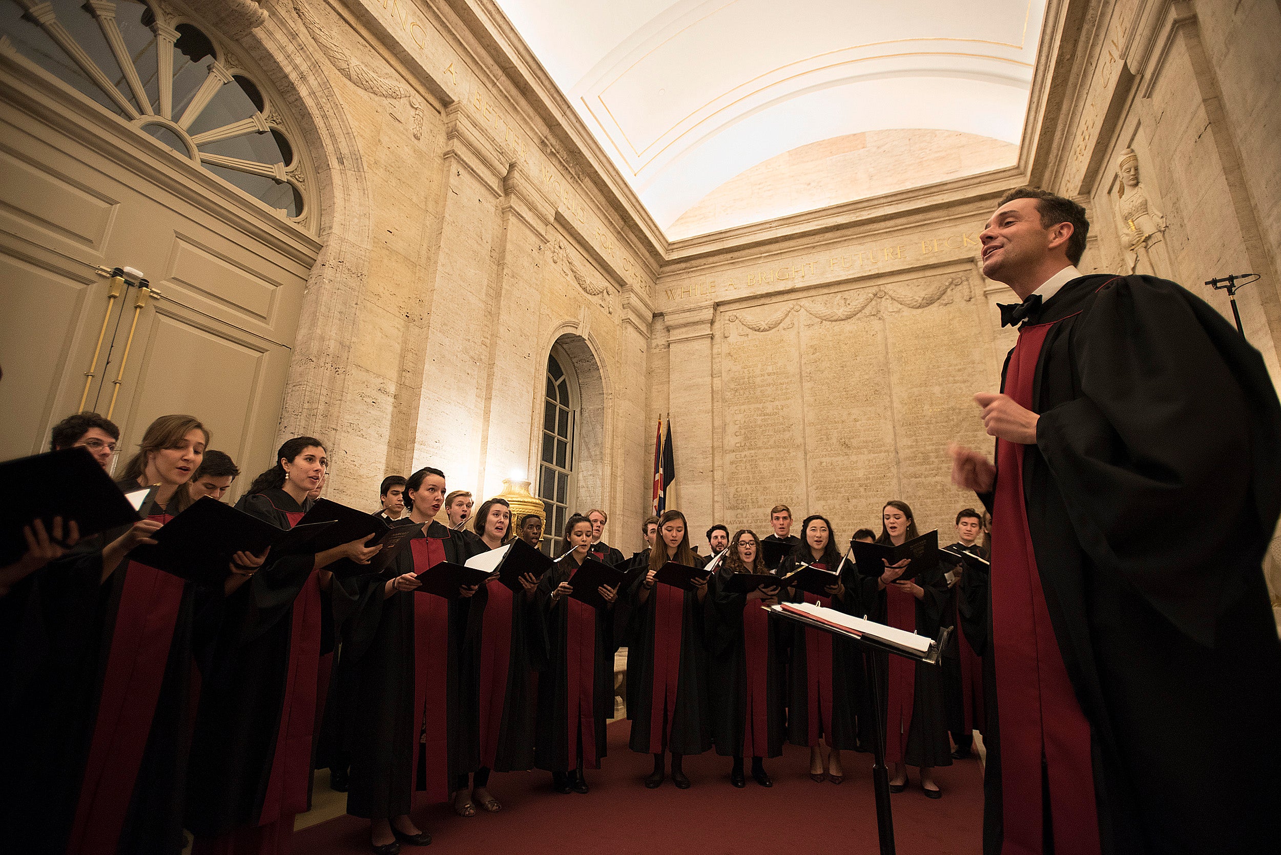 Choir singers ring conductor.