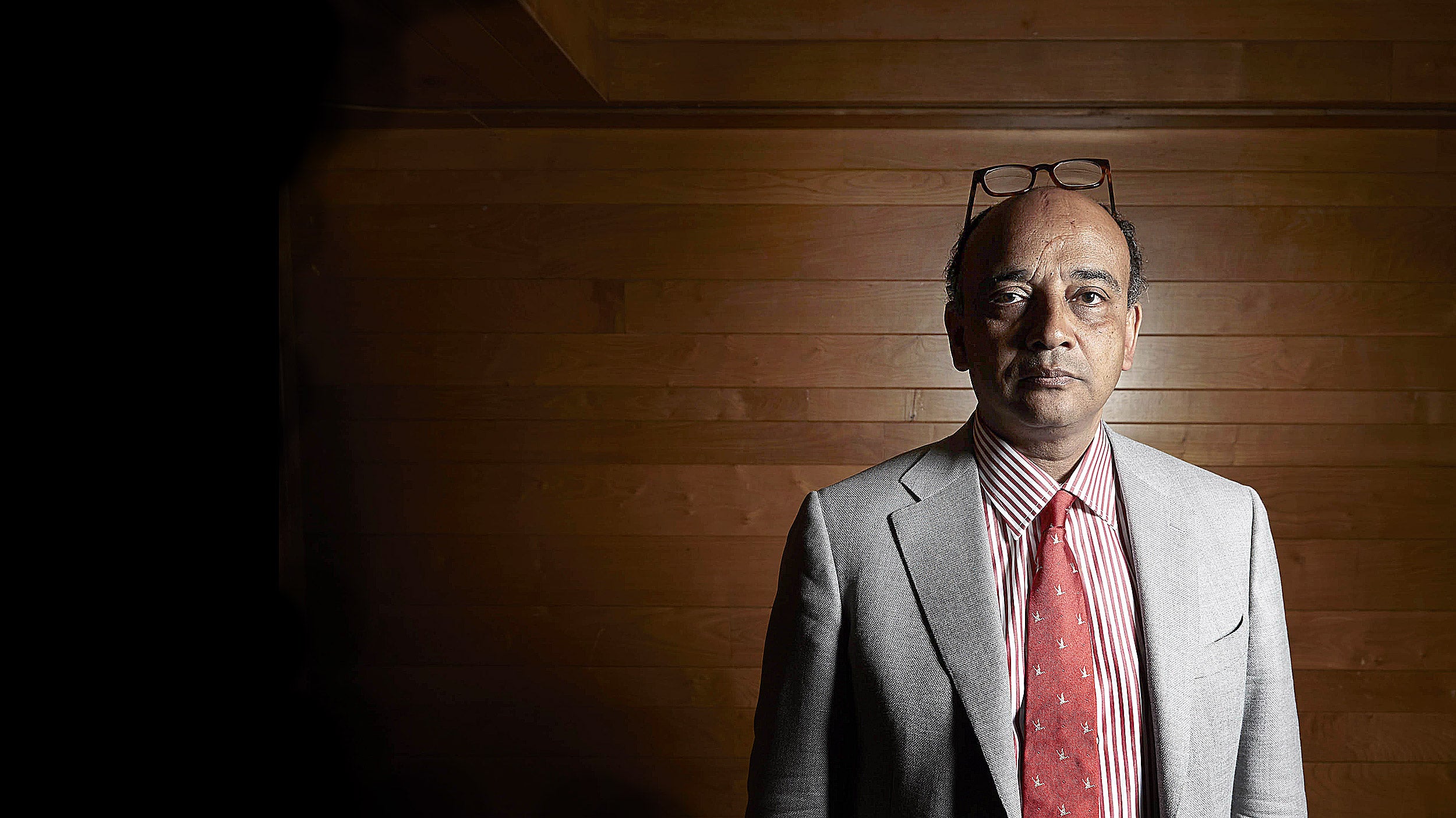 Kwame Anthony Appiah in front of a wooden wall