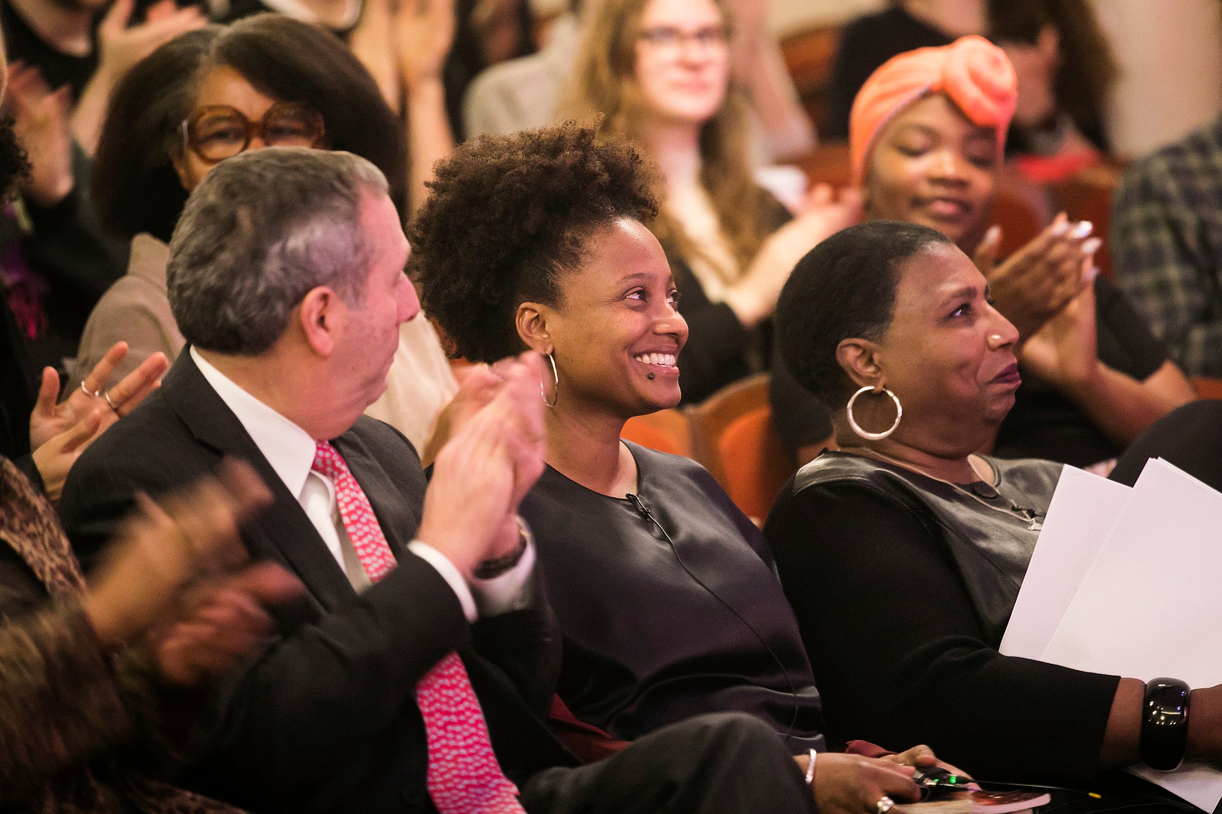 U.S. poet laureate Tracy K. Smith ’94, center, is applauded by Harvard President Larry Bacow, left, and journalist Callie Crossley, right