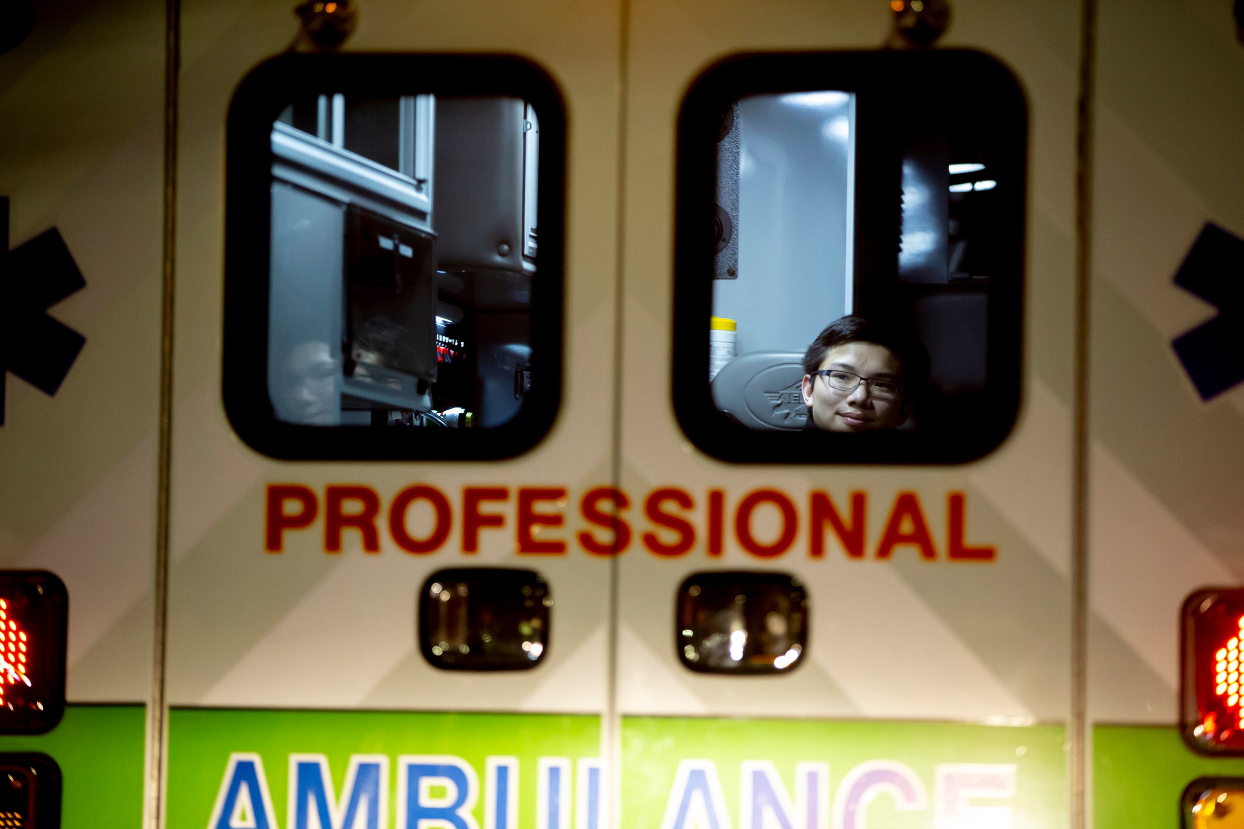 Benjamin Ho is seen through the back door of an ambulance.