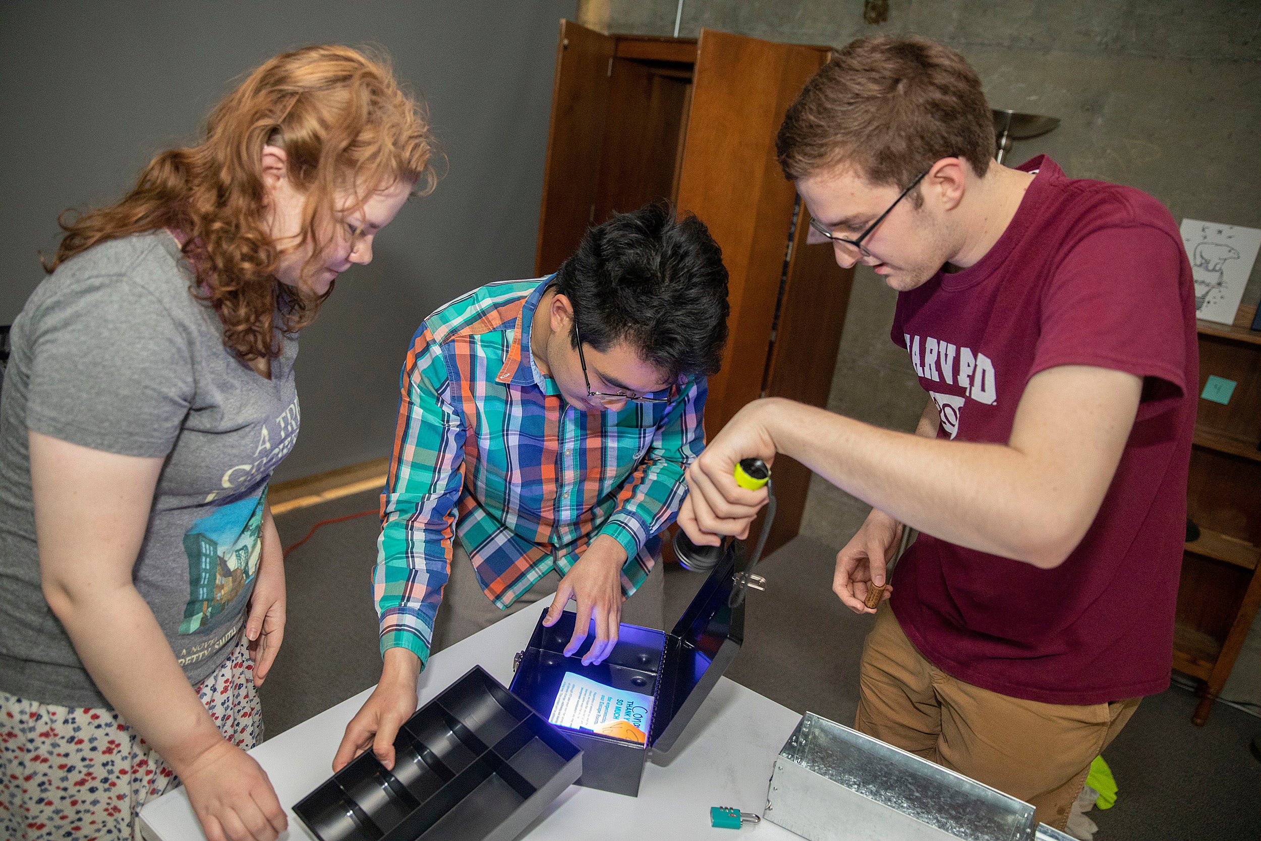 Jena Lorman (left), Michael Cheng, and Tyler Morris solve puzzles in a sustainability-themed "escape room."