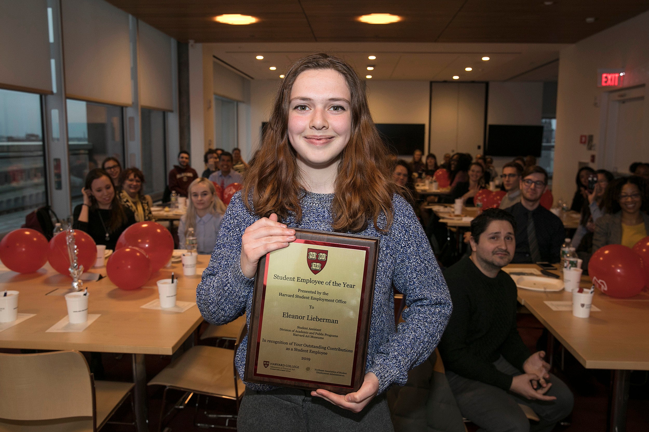Eleanor Lieberman holds her Student Employee of the Year plaque
