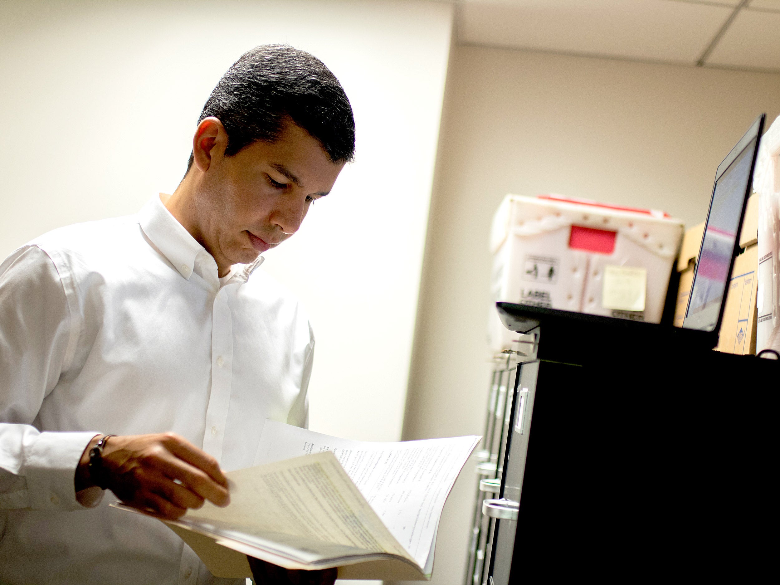 Salvador Peña looks at a file in an office
