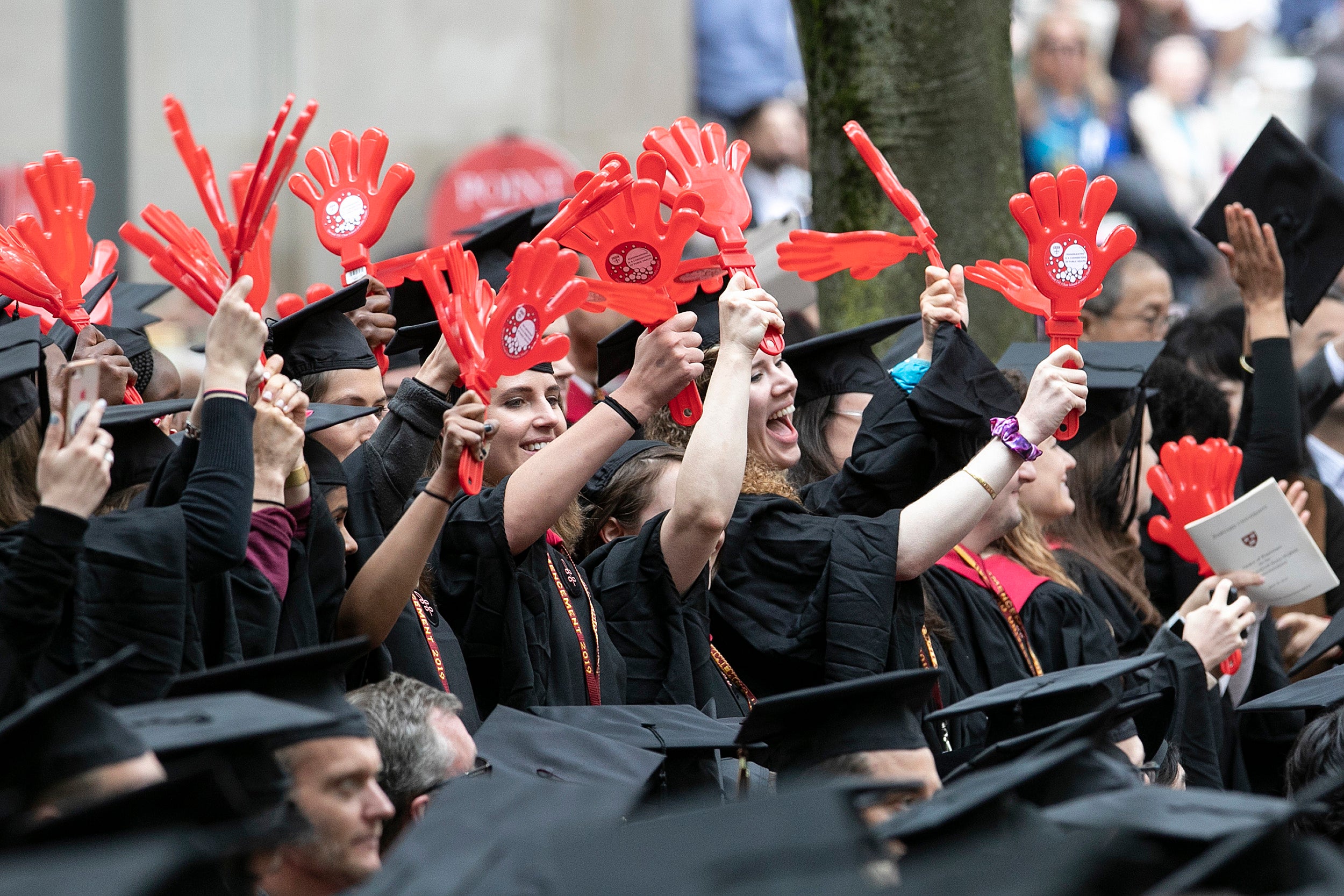 Harvard T.H. Chan School of Public Health graduates wave with red plastic clappers