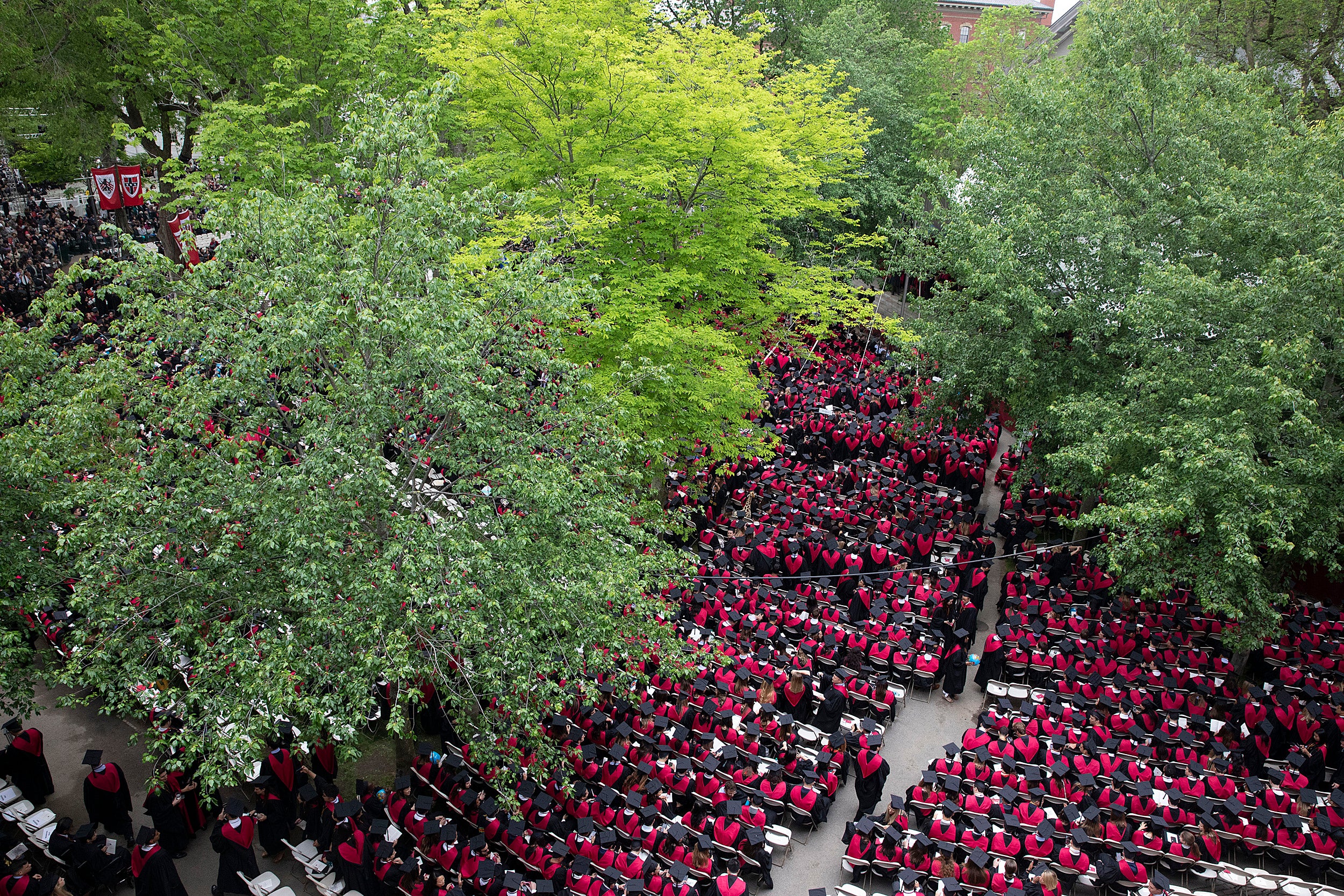 A birds eye view of a sea of Business School Graduates in red robes during Commencement morning exercises