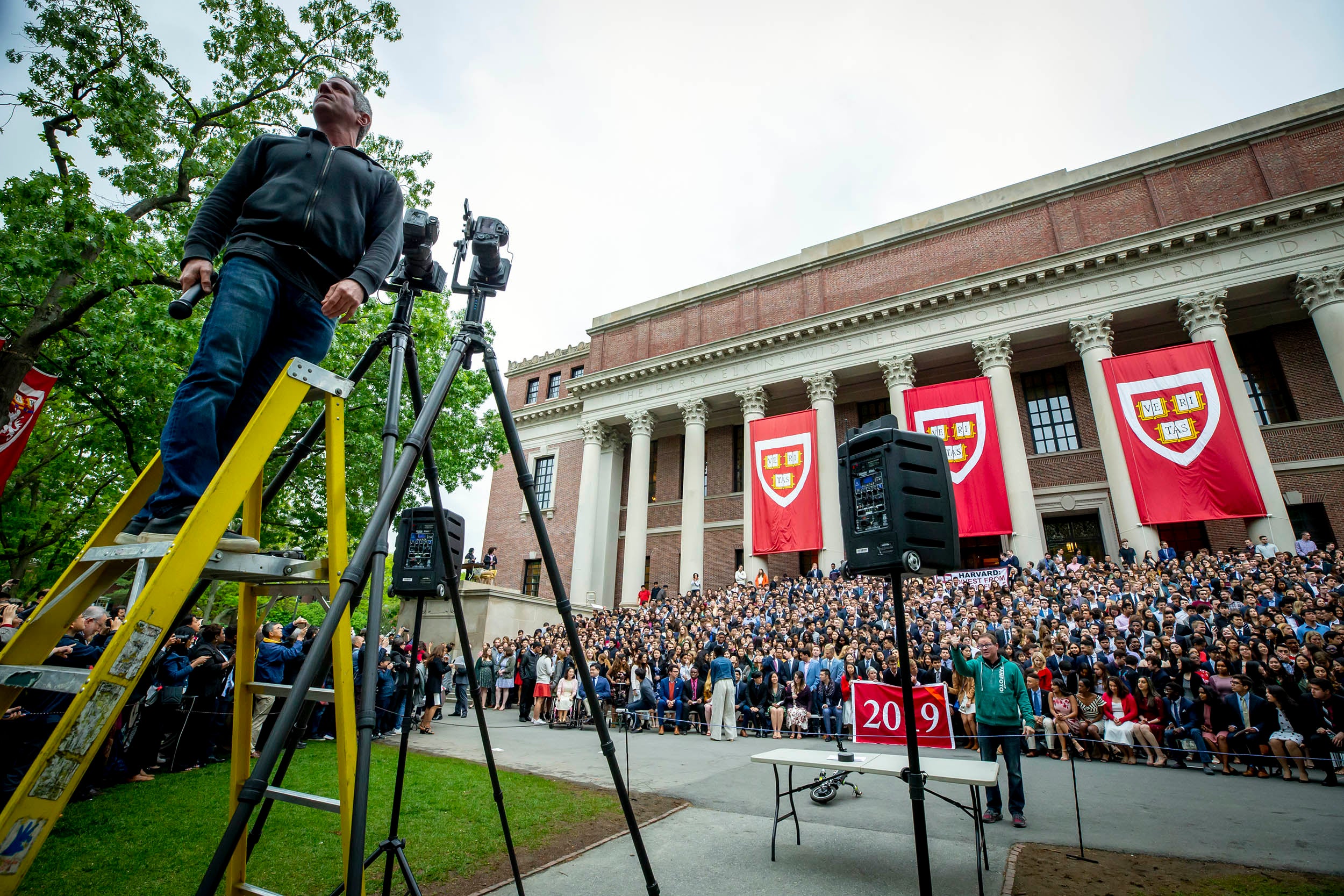 Photographer sets up class photo of graduates on the steps of Widener Library.