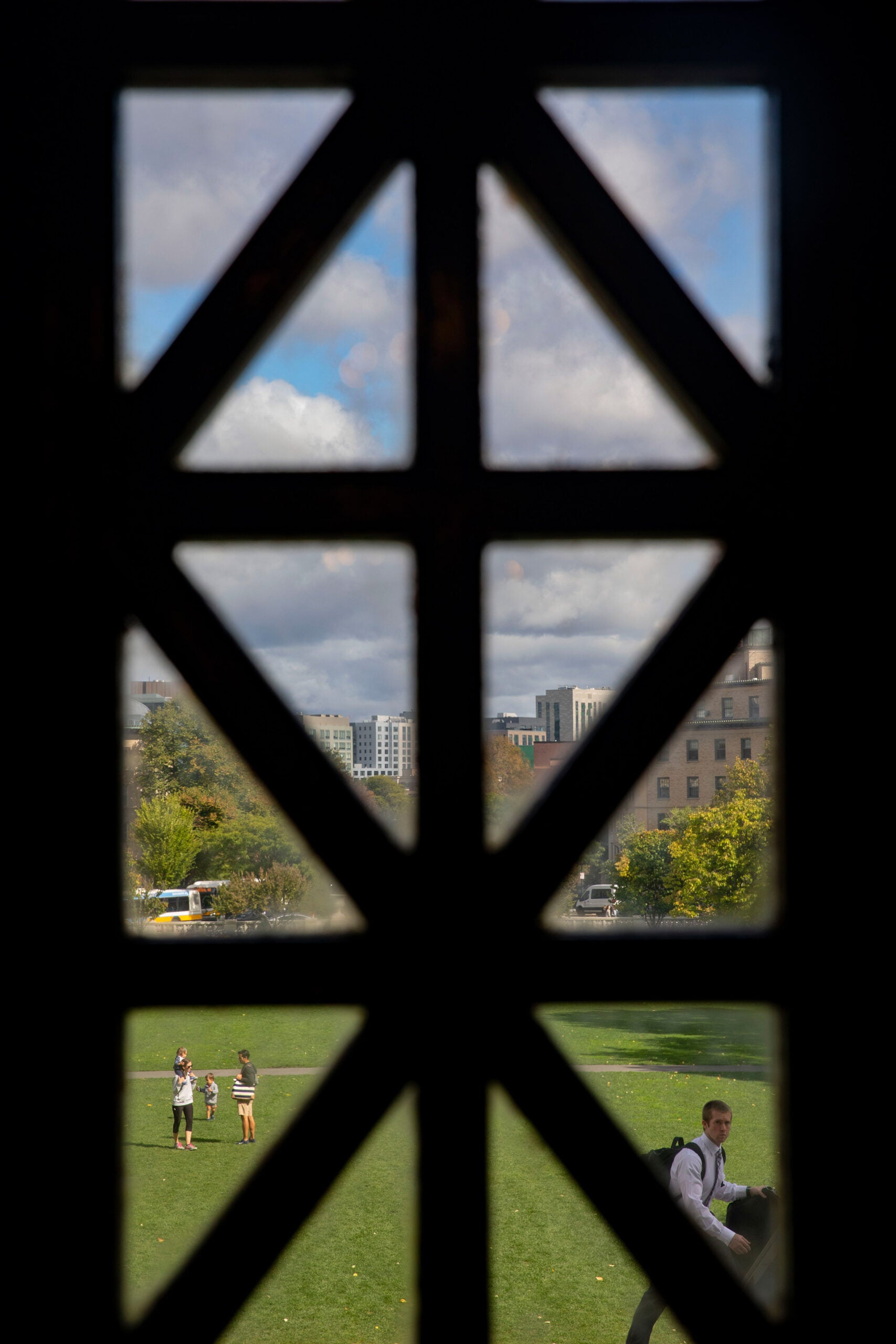 A dark window frames a family in the courtyard at Harvard Medical School.
