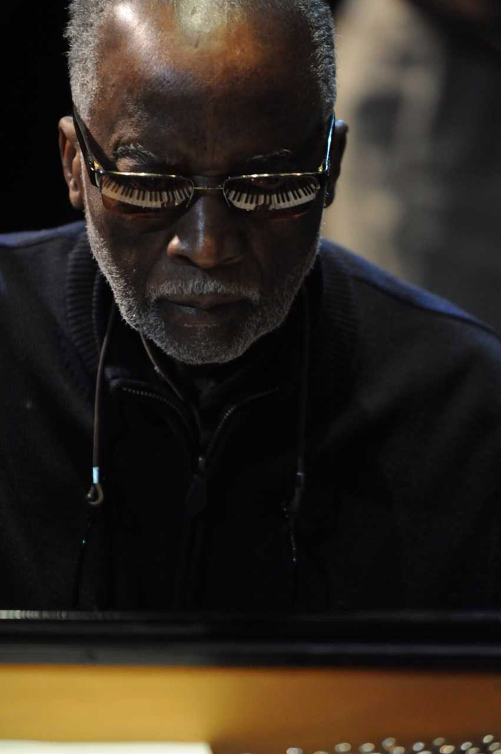 Ahmad Jamal, 2013 with piano keys reflected in glasses