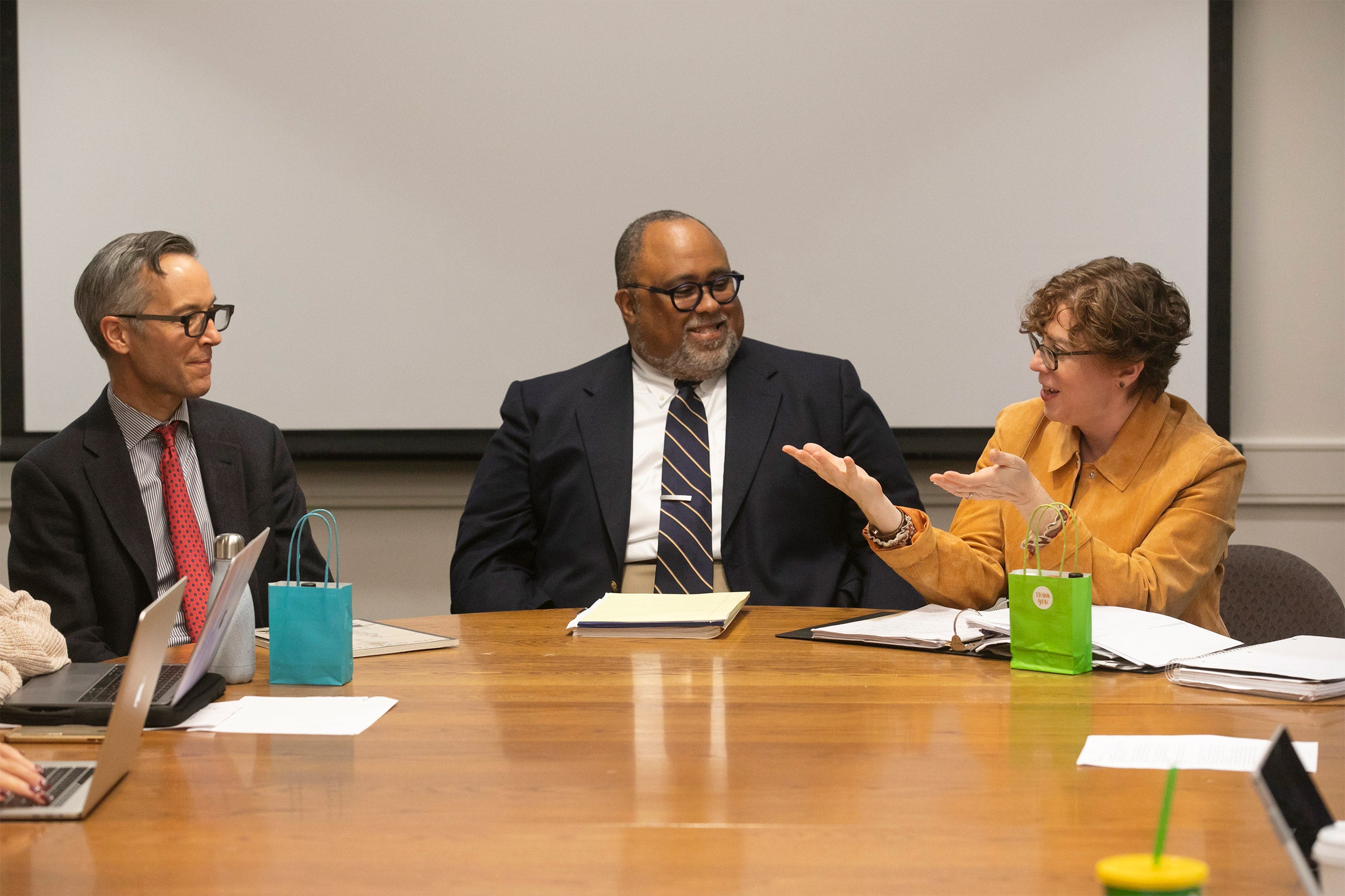 Professor Robin Bernstein speaking with Deans Robin Kelsey and Lawrence Bobo at a conference table.