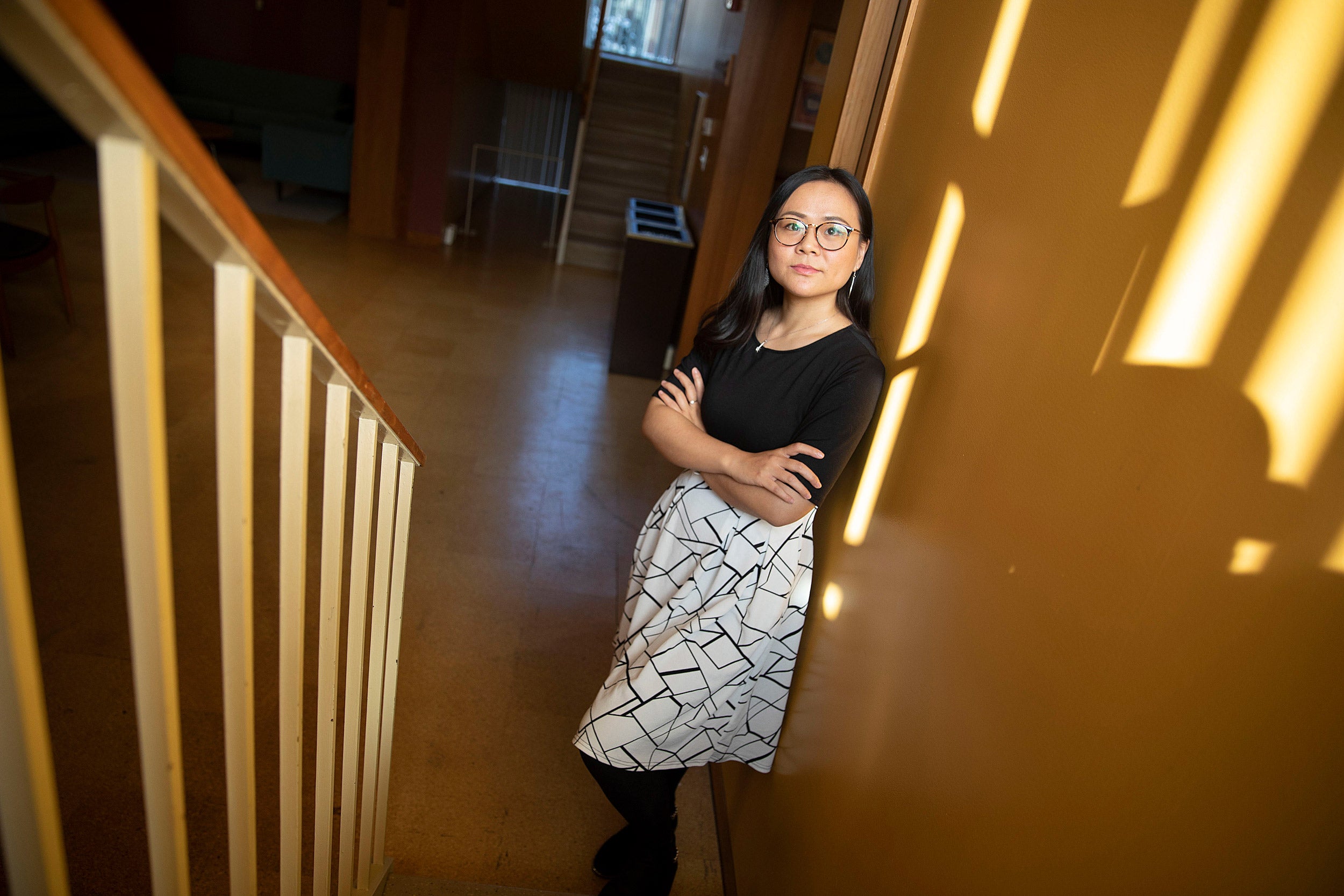 Asian woman standing in stairwell.