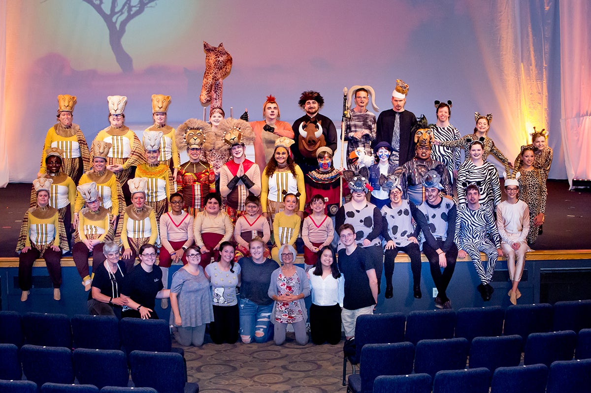 A group of people in lion king costumes standing on bleachers