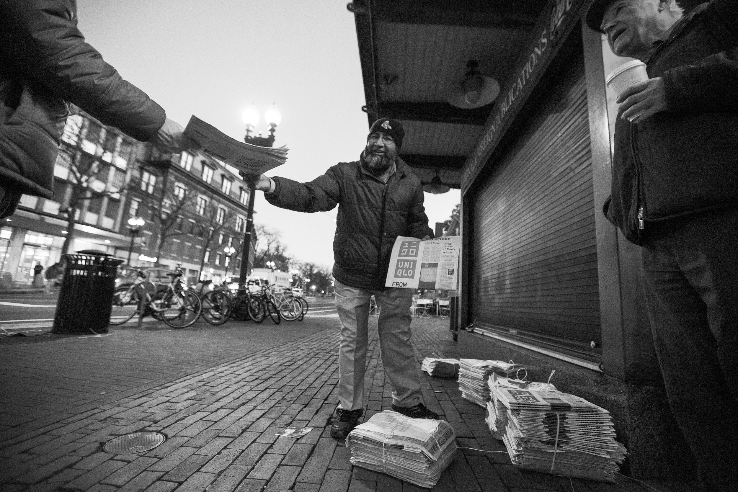 Mohamed Rahman hands out newspapers in Harvard Square.