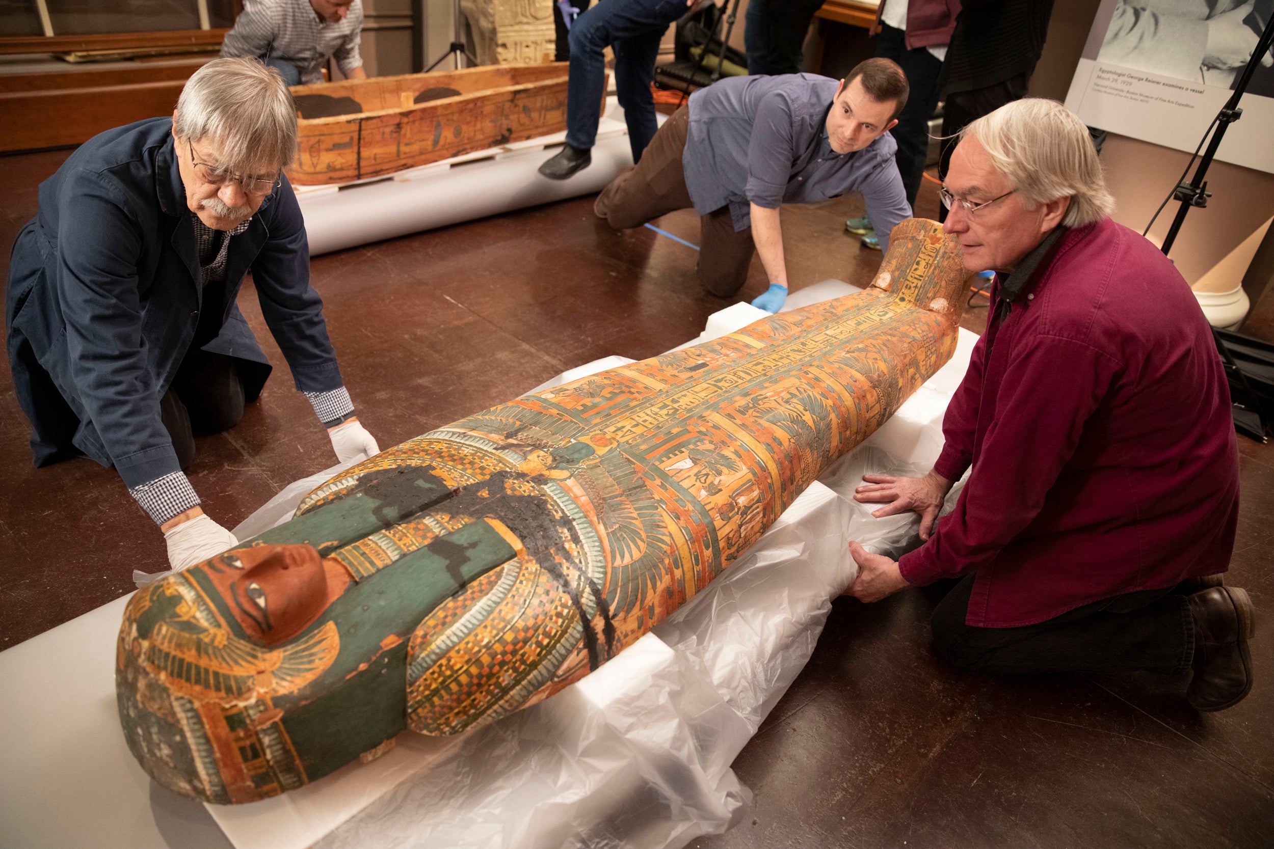 Conservators carefully position colorful closed coffin of Ankh-khonsu.