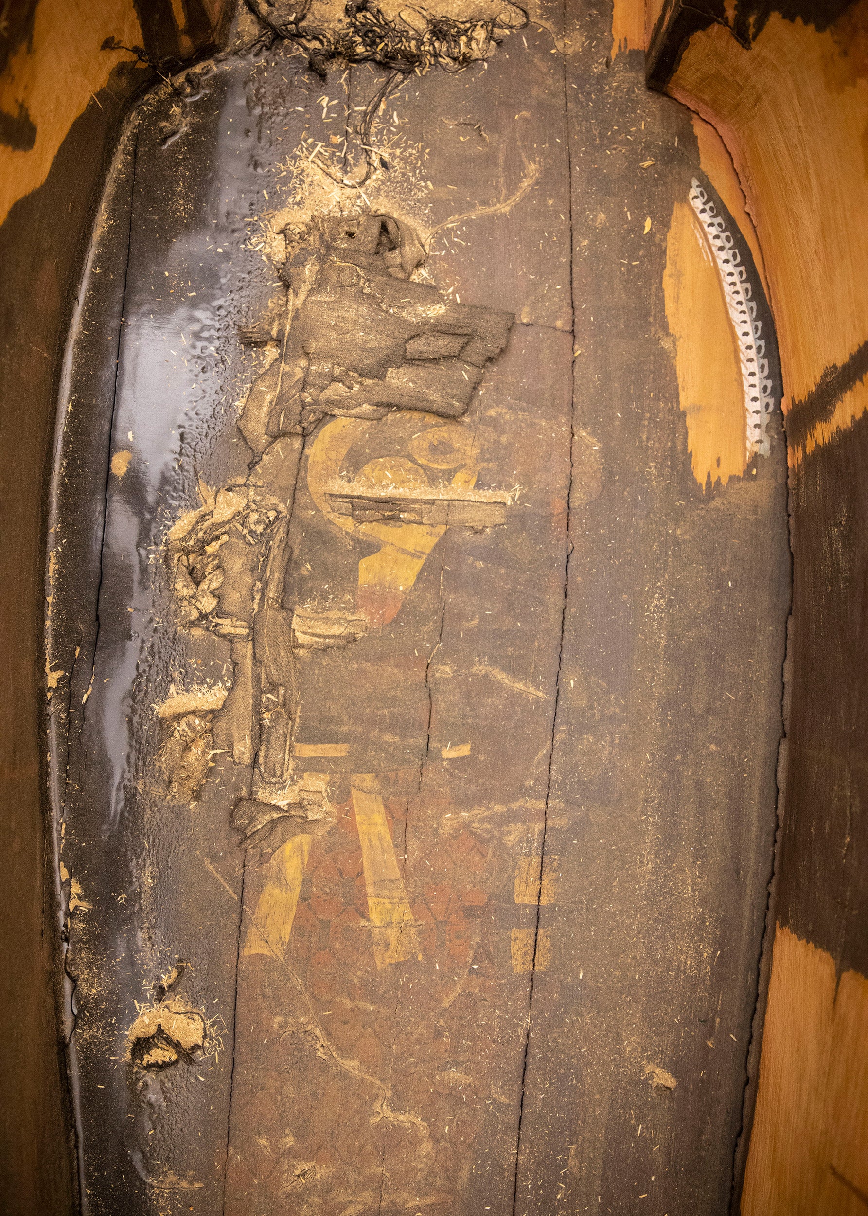 Detail of the sun god painted inside Ankh-khonsu's coffin, partially covered by a tar-like coating.