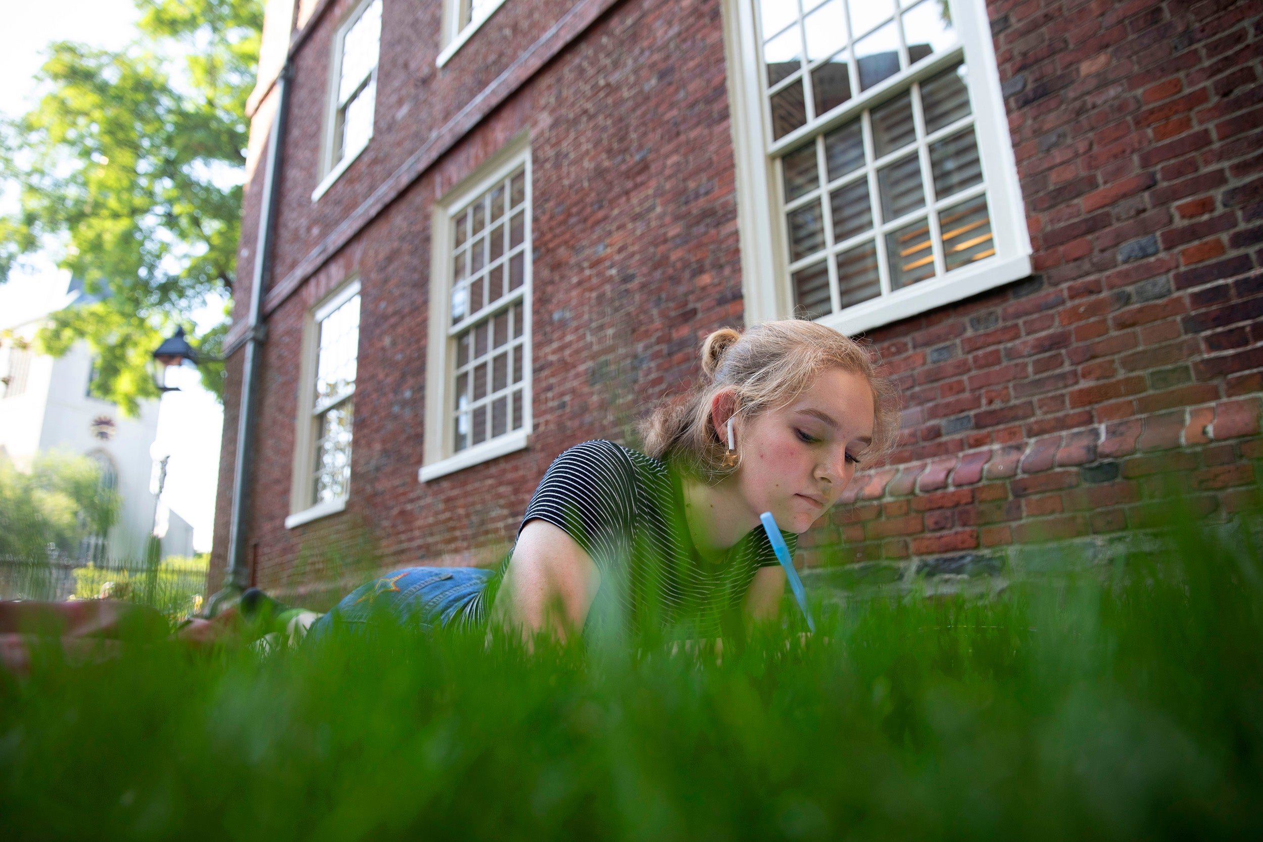 Behind Massachusetts Hall, Grace Carlson ’23 enjoys an 80-degree fall day.