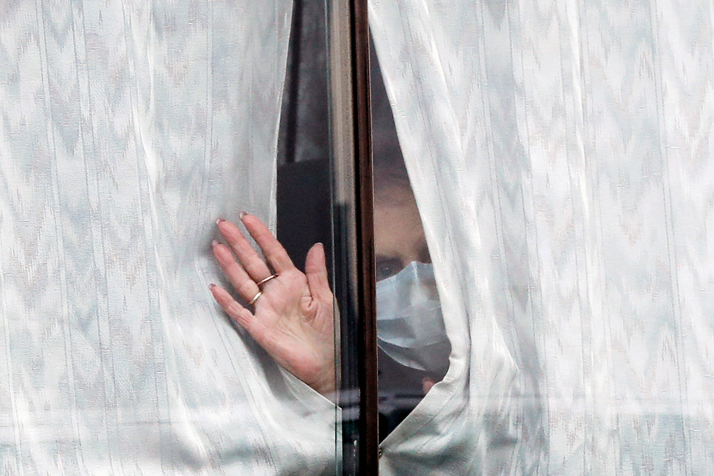 A woman waves from a window.