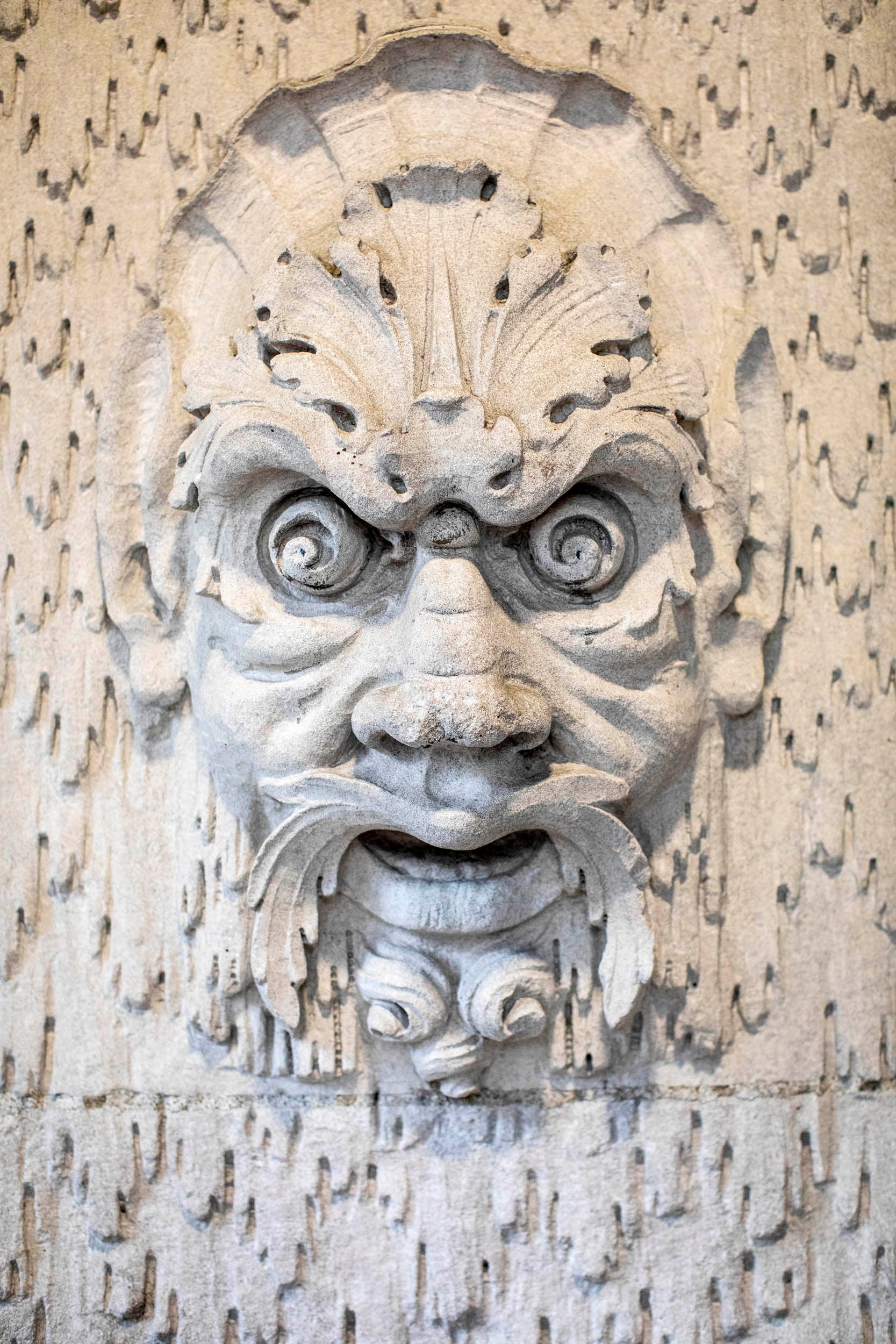 A faced carved in stone greets visitors at Randolph Hall’s Westmorly Court entrance.