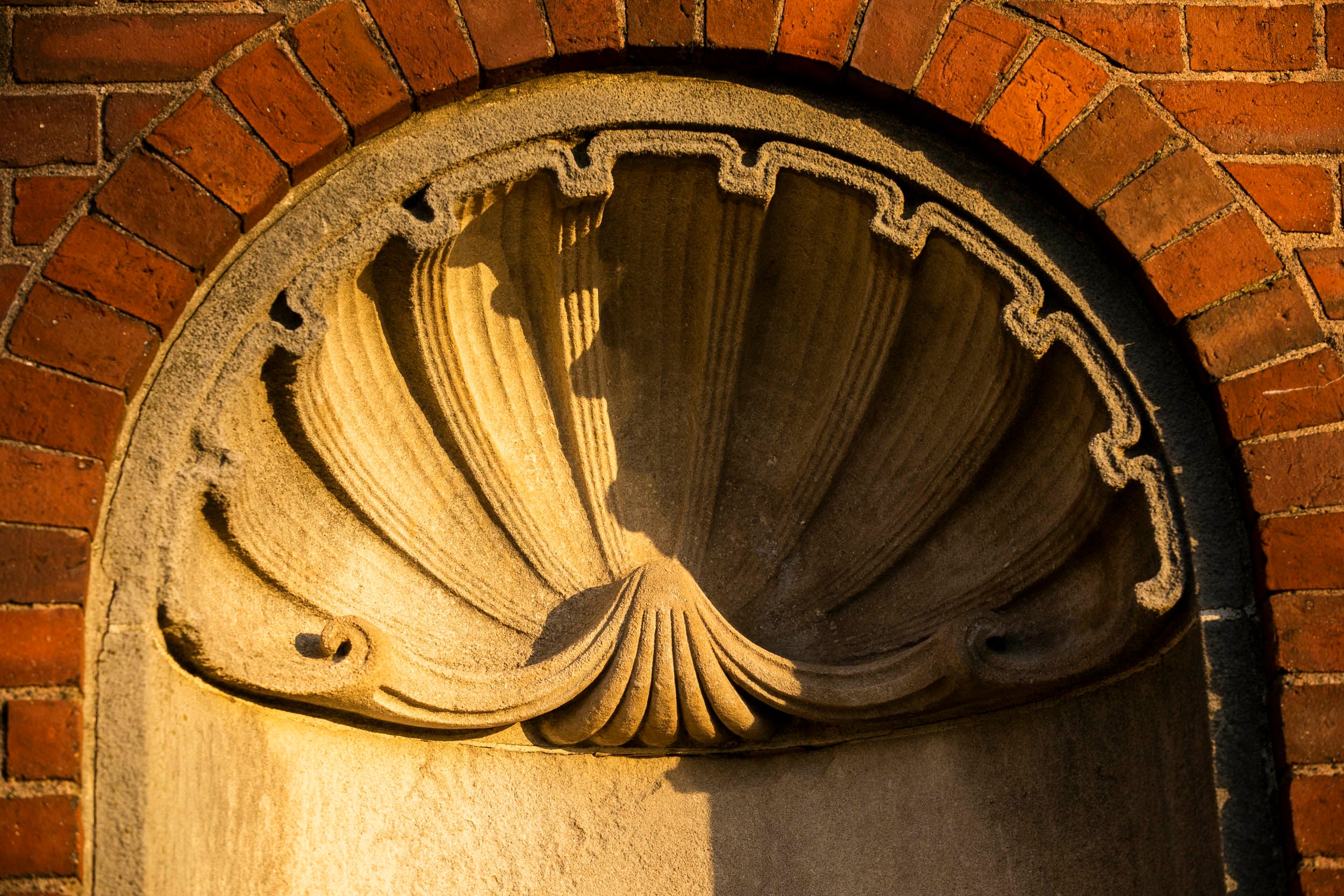 A shell design is pictured along the brick wall of Eliot House.