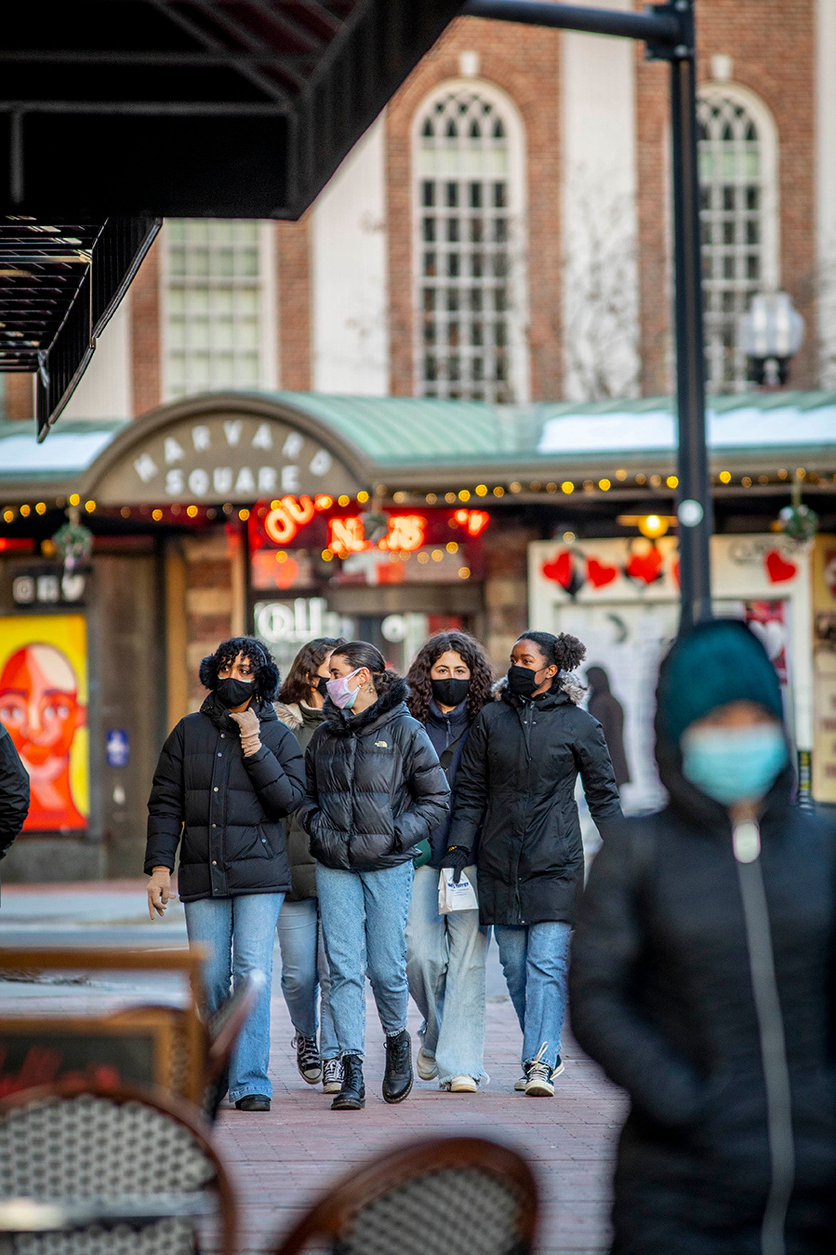 Masked pedestrians walk through Harvard Square.