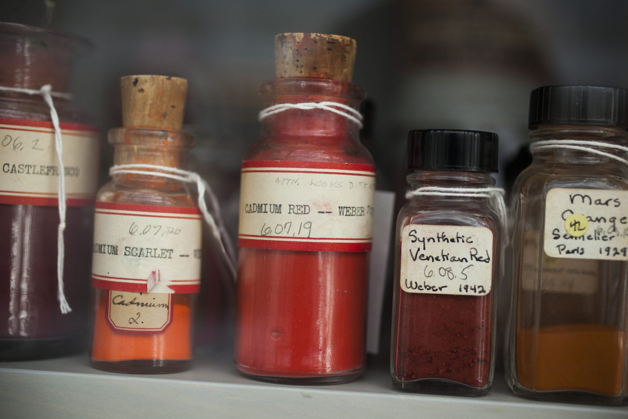 a collection of pigments in glass jars.