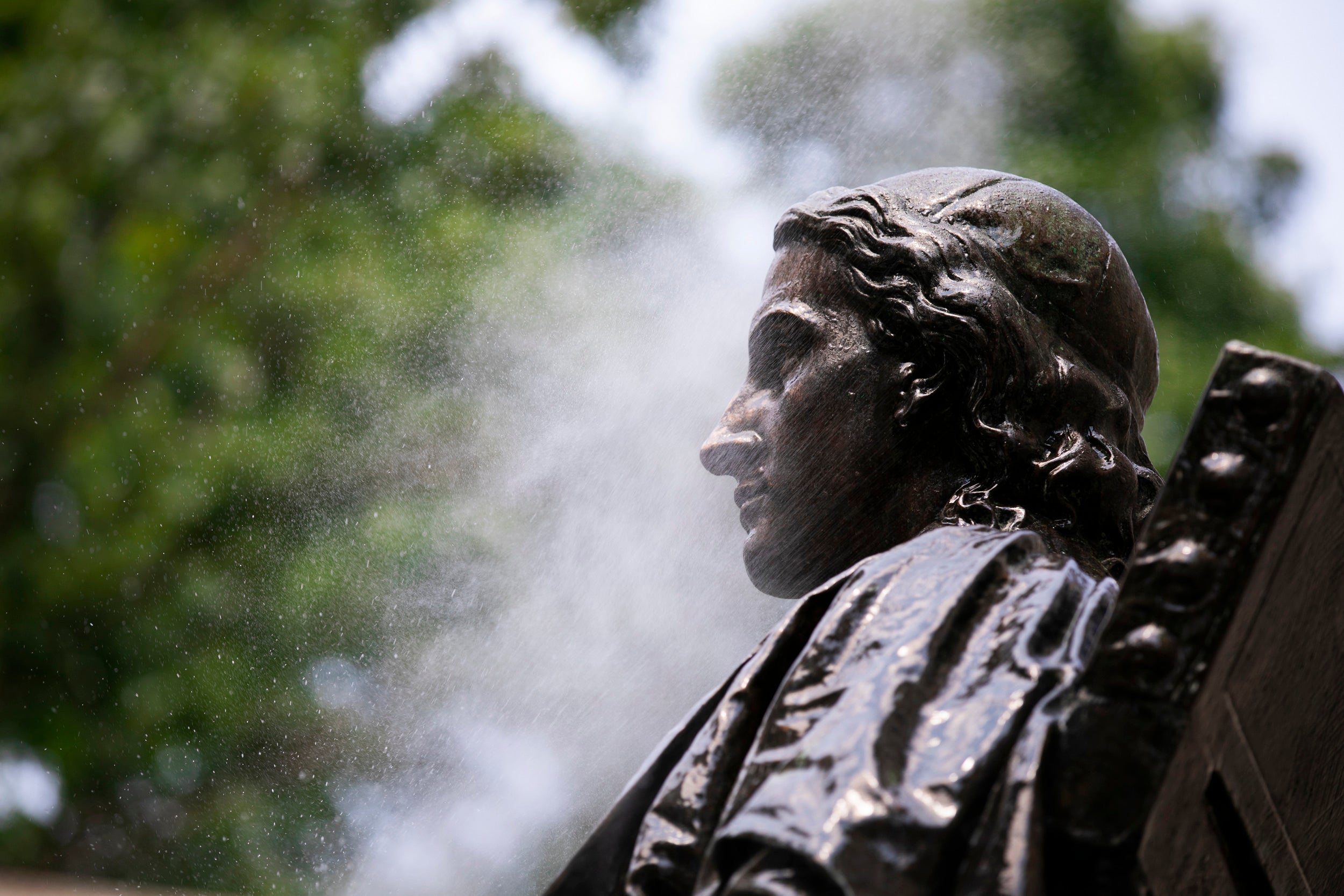 John Harvard statue being cleaned.