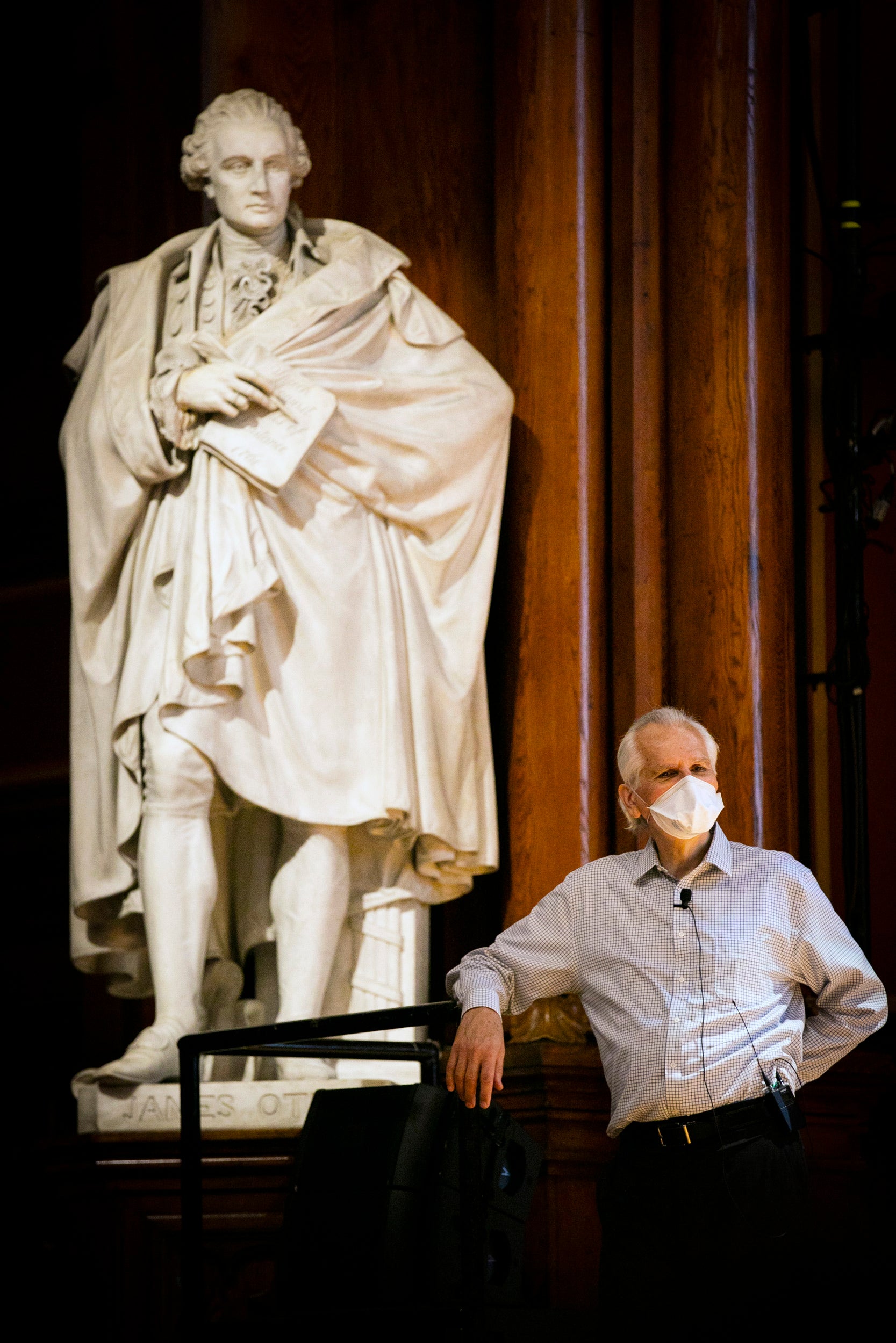 Charles Czeisler stands by the statue in Sanders Theatre during his lecture on Sleep.
