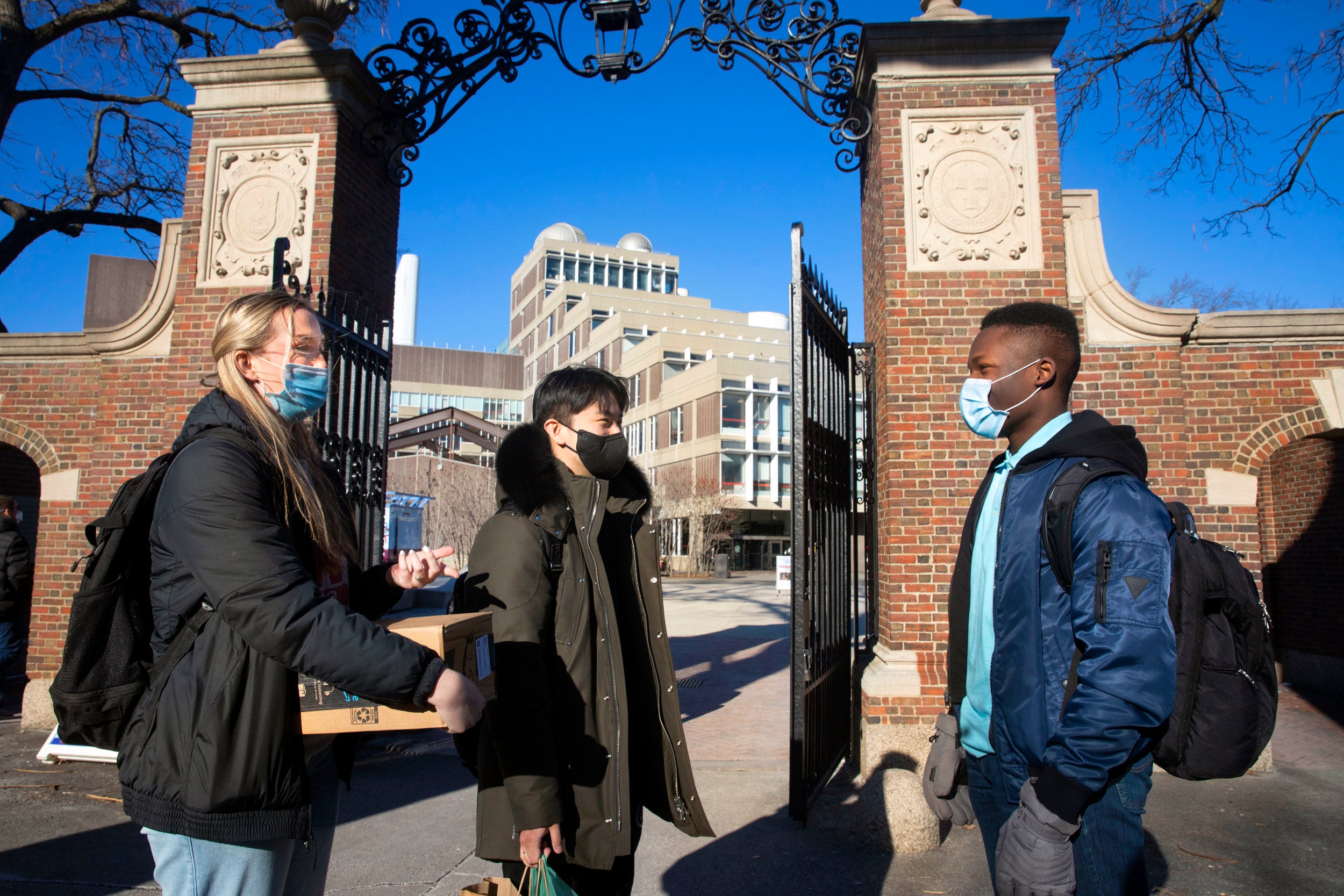 Beneath the Science Center gate, first-years Cara Salsberry (from left), Christian Um, and Ejike Ike chat.