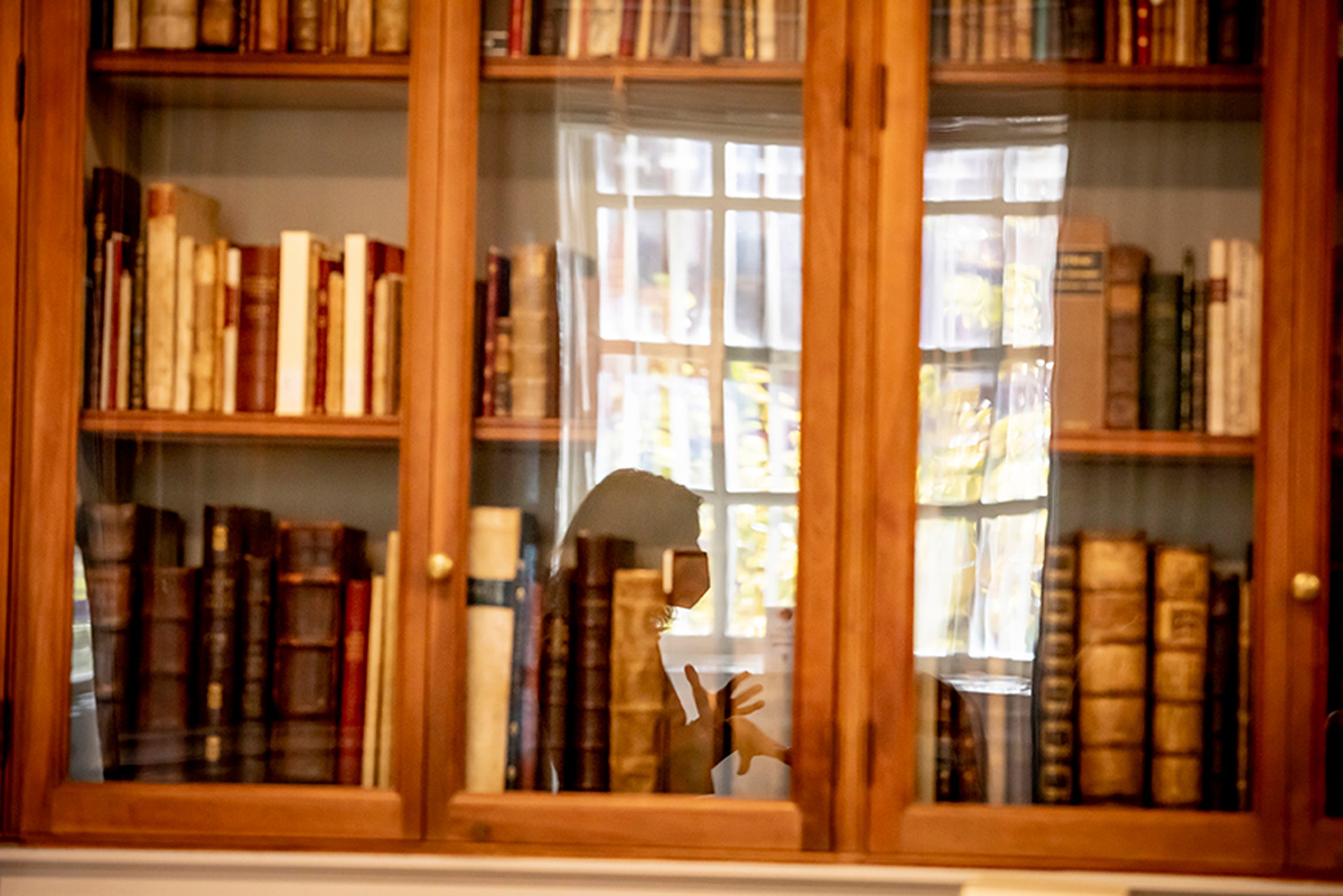 Irene Peirano Garrison reflected in bookcase.