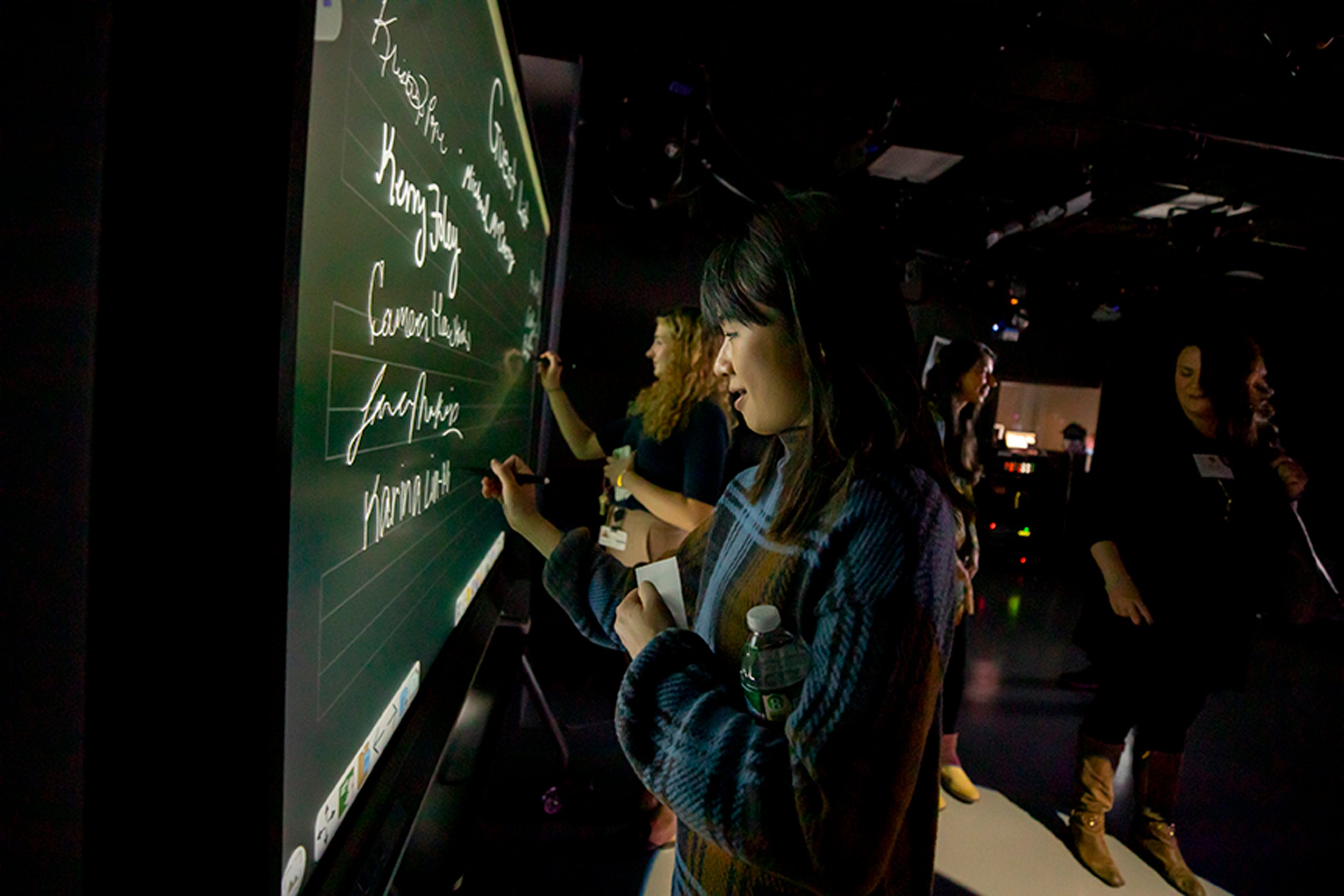 Karina Lin-Murphy writes her name on the welcome board in the new tv studio