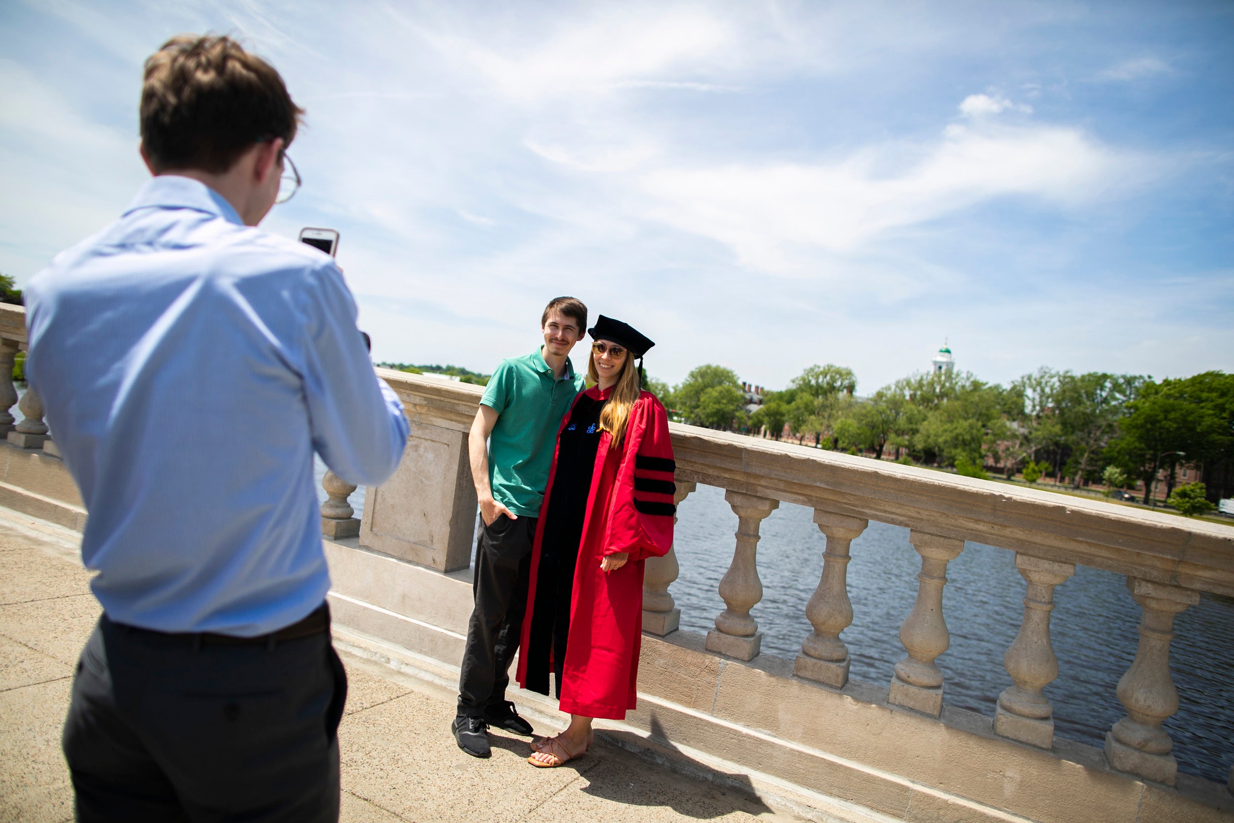 Brianna Duncan-Lowey (right), who graduated with a Ph.D. in virology, is pictured with her brother, Colin, on the Weeks Footbridge following the Morning Exercises.