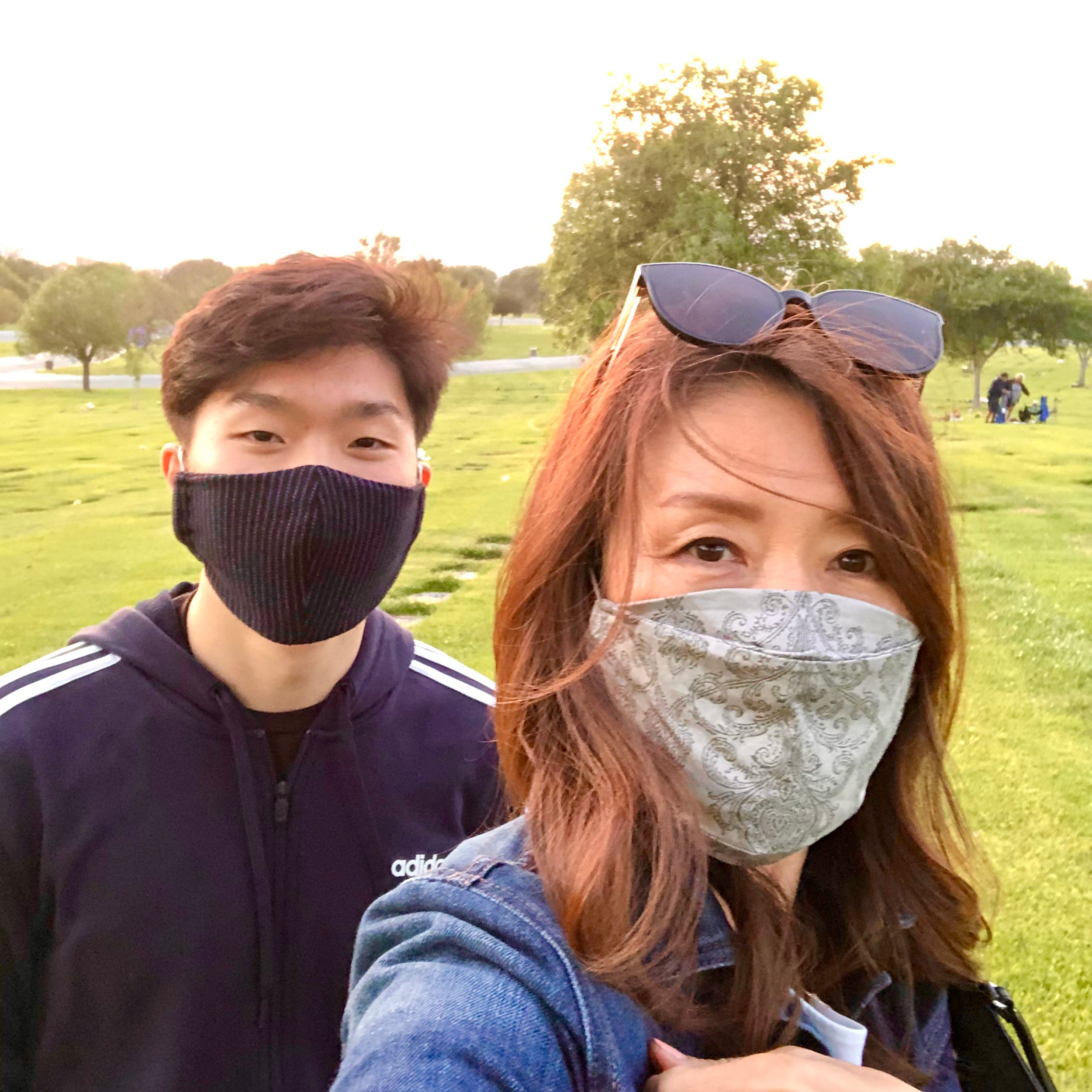 Elijah and Karen Suh pose for selfie wearing masks.