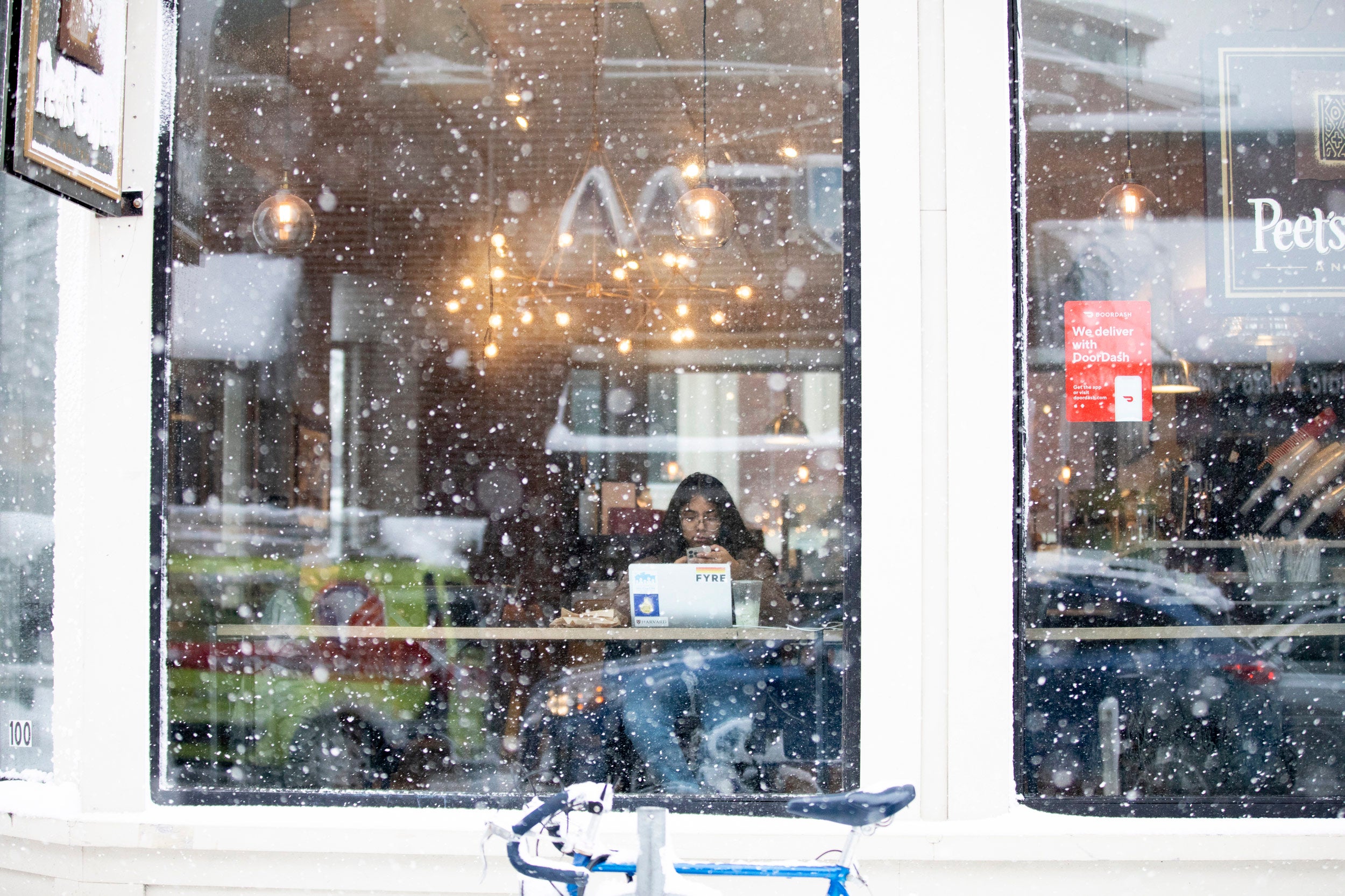 Snow falling outside a coffee shop.