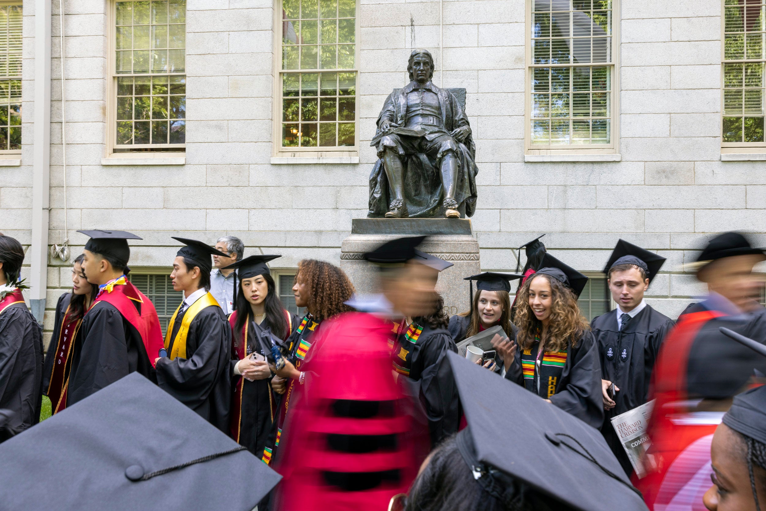 Graduates stream past John Harvard Statue on way to Tercentenary Theatre.