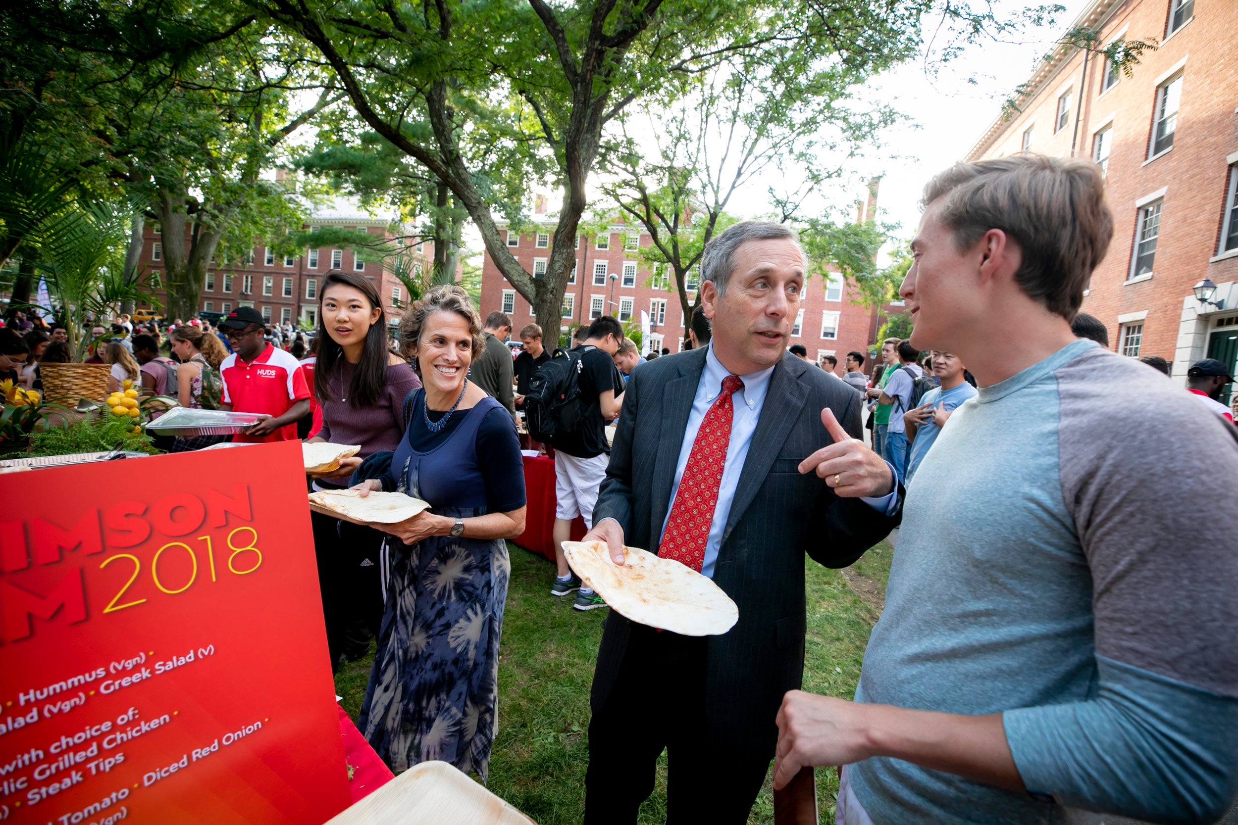 With his wife, Adele, Bacow mingled with students Trey Sexton (right) and Annie Miall during Crimson Jam, a concert in Harvard Yard.