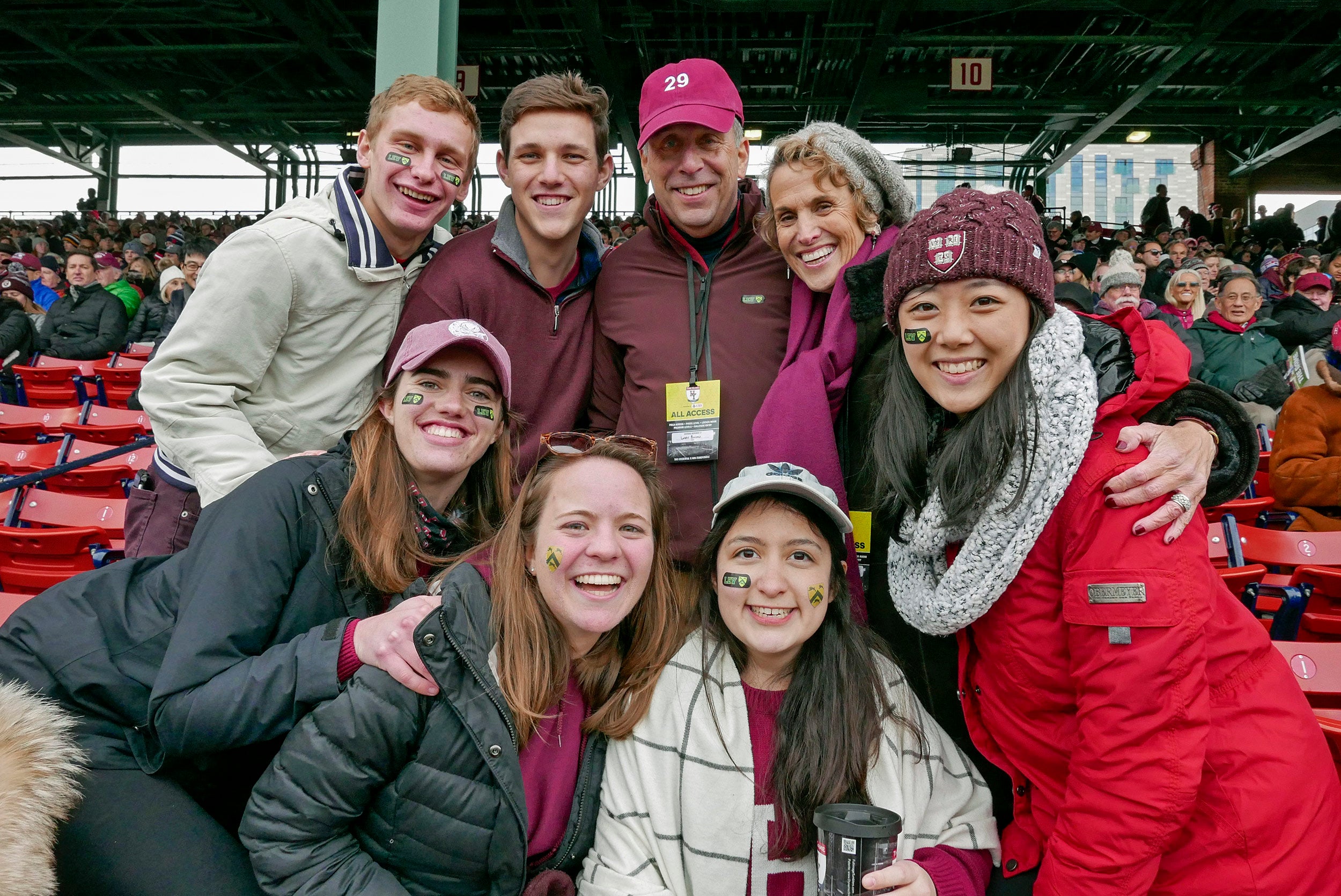 Larry and Adele Bacow celebrate with fans at the Harvard-Yale football game at Fenway Park.