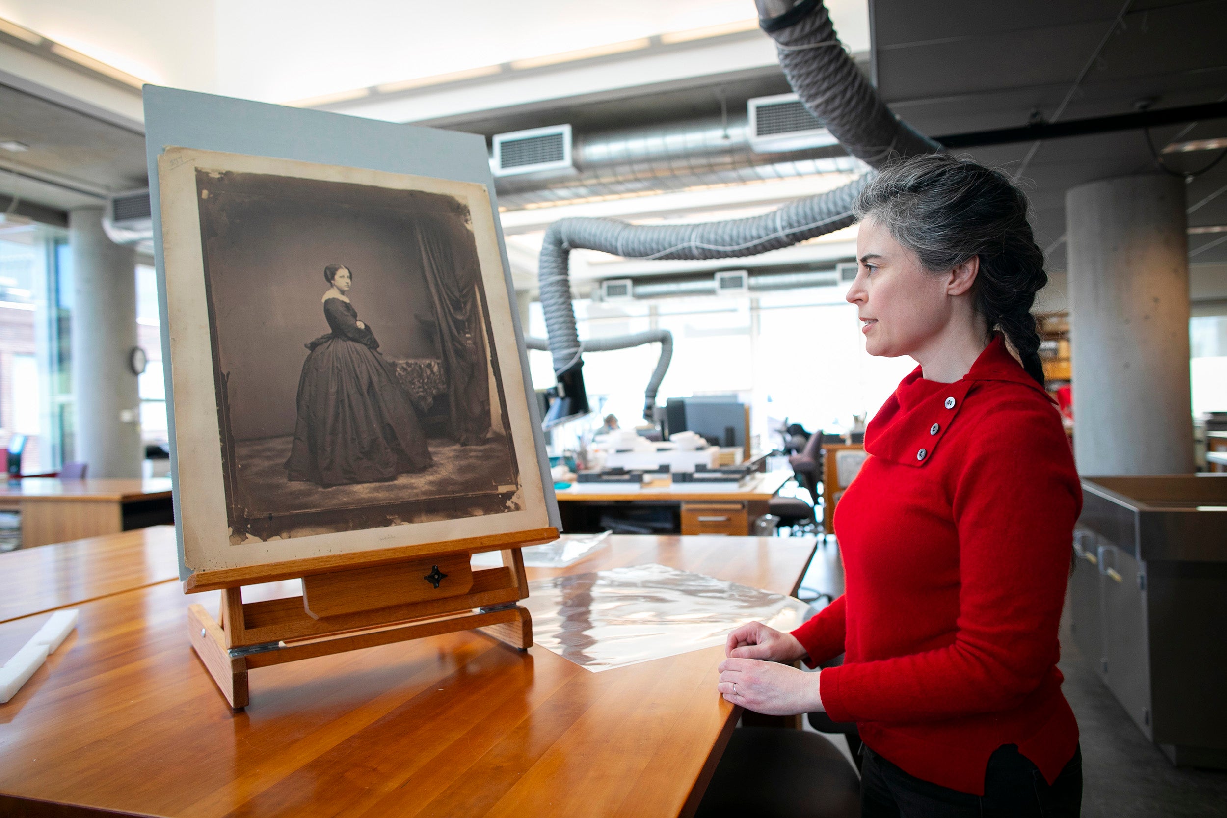 Amanda Maloney looks at a salt print propped up on an easel in the Weissman Preservation Center.